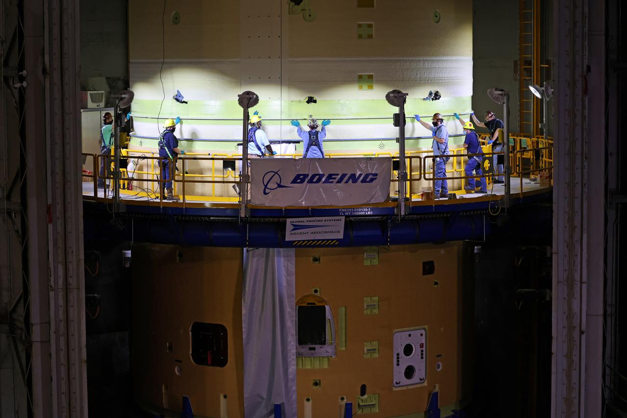 This image shows technicians and engineers move and connect the liquid oxygen tank (LOX) to the intertank as they continue the process of the forward join on the core stage of NASA’s Space Launch System rocket for Artemis II, the first crewed mission of NASA’s Artemis program at NASA’s Michoud Assembly Facility. The forward join connects the forward skirt, the liquid oxygen tank (LOX) and the intertank structures to form the top part of the SLS rocket’s core stage. Now, NASA and Boeing, the SLS prime contractor, will continue to integrate various systems inside the forward part of the core stage and prepare for structural joining of the liquid hydrogen tank and engine section to form the bottom of the stage.  Together with its four RS-25 engines, the rocket’s massive 212-foot-tall core stage — the largest stage NASA has ever built — and its twin solid rocket boosters will produce 8.8 million pounds of thrust to send NASA’s Orion spacecraft, astronauts and supplies beyond Earth’s orbit to the Moon and, ultimately, Mars. Offering more payload mass, volume capability and energy to speed missions through space, the SLS rocket, along with NASA’s Gateway in lunar orbit, the Human Landing System, and Orion spacecraft, is part of NASA’s backbone for deep space exploration and the Artemis lunar program. No other rocket is capable of carrying astronauts in Orion around the Moon in a single mission. Image credit: NASA/Michael DeMocker 