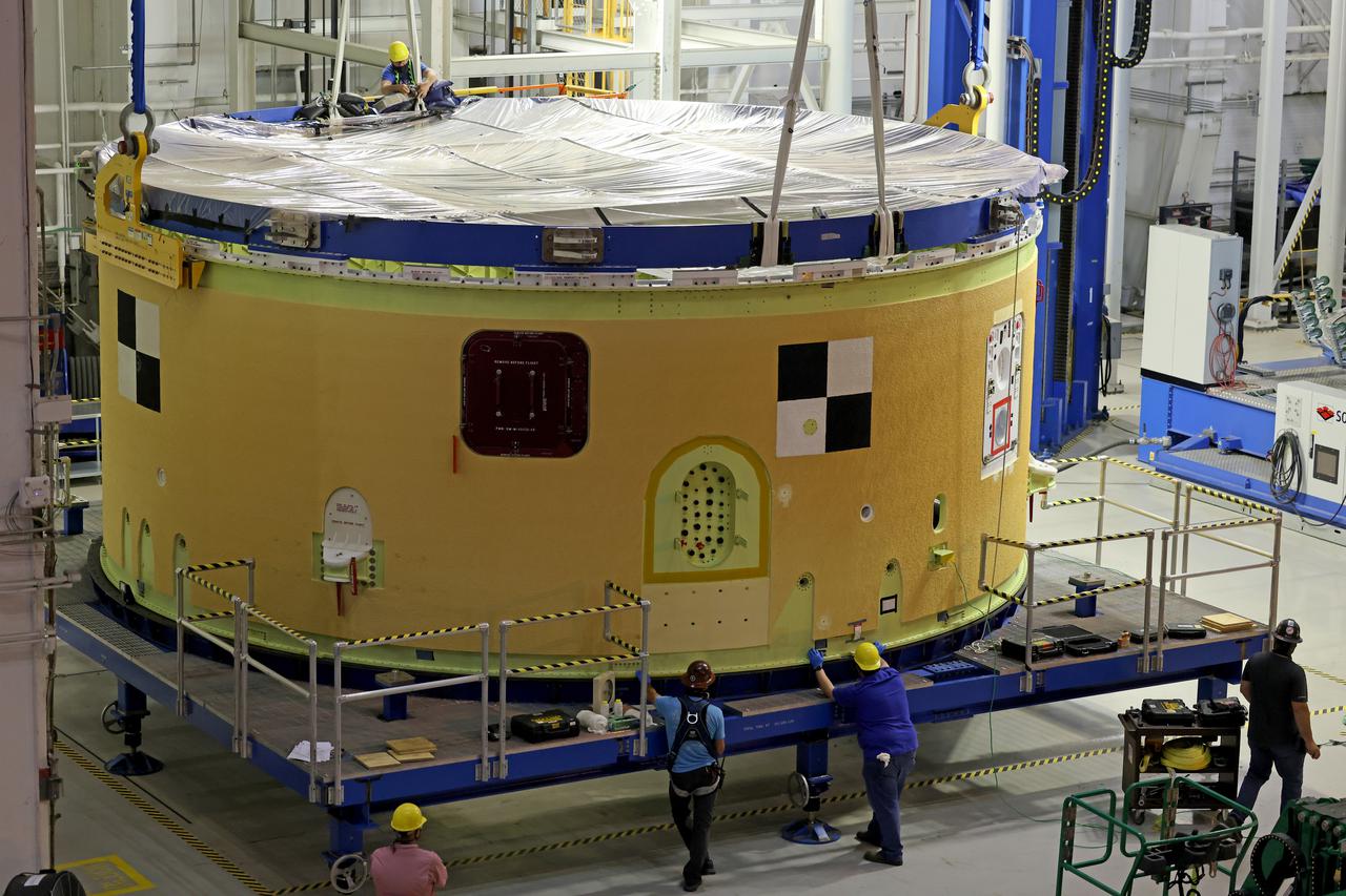 This image shows technicians and engineers preparing to movie and connect the forward skirt to the liquid oxygen tank (LOX) as they continue the process of the forward join on the core stage of NASA’s Space Launch System rocket for Artemis II, the first crewed mission of NASA’s Artemis program at NASA’s Michoud Assembly Facility. The forward join connects the forward skirt, the liquid oxygen tank (LOX) and the intertank structures to form the top part of the SLS rocket’s core stage. Now, NASA and Boeing, the SLS prime contractor, will continue to integrate various systems inside the forward part of the core stage and prepare for structural joining of the liquid hydrogen tank and engine section to form the bottom of the stage.  Together with its four RS-25 engines, the rocket’s massive 212-foot-tall core stage — the largest stage NASA has ever built — and its twin solid rocket boosters will produce 8.8 million pounds of thrust to send NASA’s Orion spacecraft, astronauts and supplies beyond Earth’s orbit to the Moon and, ultimately, Mars. Offering more payload mass, volume capability and energy to speed missions through space, the SLS rocket, along with NASA’s Gateway in lunar orbit, the Human Landing System, and Orion spacecraft, is part of NASA’s backbone for deep space exploration and the Artemis lunar program. No other rocket is capable of carrying astronauts in Orion around the Moon in a single mission. Image credit: NASA/Michael DeMocker 