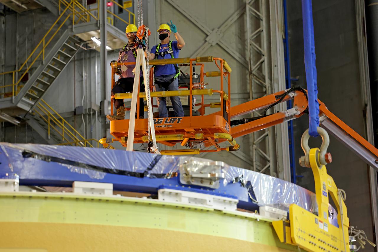 NASA’s Space Launch System (SLS) team fully stacked three hardware elements together May 24 to form the top of the rocket’s core stage for the Artemis II mission. NASA and core stage prime contractor Boeing connected the forward skirt with the liquid oxygen tank and intertank flight hardware inside an assembly area at NASA’s Michoud Assembly Facility in New Orleans. Teams had previously stacked the liquid oxygen tank and intertank on April 28. The joining of the three structures together is the first major assembly of core stage hardware for Artemis II, the first crewed Artemis mission and second flight of the SLS rocket. Next, technicians will work to complete outfitting and integrating the systems within the upper structure.   At 66 feet tall, the upper part of the stage is just a fraction of the entire core stage. The fully-assembled, 212-foot-tall rocket stage consists of five hardware elements, including two liquid propellant tanks and four RS-25 engines. The liquid oxygen tank in the upper portion of the stage will hold 196,000 gallons of liquid oxygen cooled to minus 297 degrees Fahrenheit. Meanwhile, the forward skirt and intertank house avionics, flight computer, and electronic systems for the rocket stage. Together, the core stage and its four RS-25 engines will provide more than 2 million pounds of thrust to help send Artemis II astronauts beyond Earth’s orbit to lunar orbit.   With Artemis, NASA will land the first woman and the first person of color on the Moon and establish sustainable exploration in preparation for missions to Mars. SLS and NASA’s Orion spacecraft, along with the commercial human landing system and the Gateway in orbit around the Moon, are NASA’s backbone for deep space exploration. SLS is the only rocket that can send Orion, astronauts, and supplies to the Moon in a single mission. Image credit: NASA/Michael DeMocker