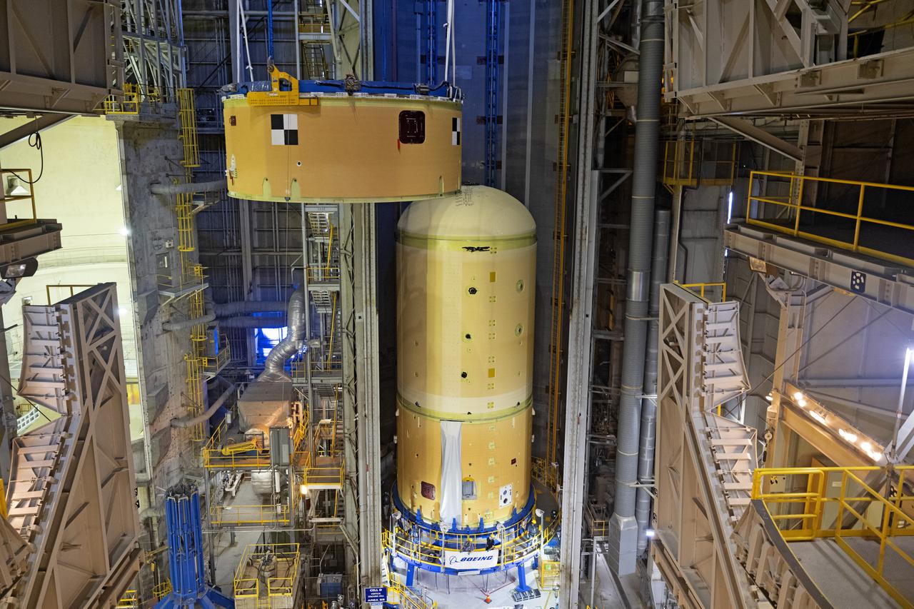 NASA’s Space Launch System (SLS) team fully stacked three hardware elements together May 24 to form the top of the rocket’s core stage for the Artemis II mission. NASA and core stage prime contractor Boeing connected the forward skirt with the liquid oxygen tank and intertank flight hardware inside an assembly area at NASA’s Michoud Assembly Facility in New Orleans. Teams had previously stacked the liquid oxygen tank and intertank on April 28. The joining of the three structures together is the first major assembly of core stage hardware for Artemis II, the first crewed Artemis mission and second flight of the SLS rocket. Next, technicians will work to complete outfitting and integrating the systems within the upper structure.   At 66 feet tall, the upper part of the stage is just a fraction of the entire core stage. The fully-assembled, 212-foot-tall rocket stage consists of five hardware elements, including two liquid propellant tanks and four RS-25 engines. The liquid oxygen tank in the upper portion of the stage will hold 196,000 gallons of liquid oxygen cooled to minus 297 degrees Fahrenheit. Meanwhile, the forward skirt and intertank house avionics, flight computer, and electronic systems for the rocket stage. Together, the core stage and its four RS-25 engines will provide more than 2 million pounds of thrust to help send Artemis II astronauts beyond Earth’s orbit to lunar orbit.   With Artemis, NASA will land the first woman and the first person of color on the Moon and establish sustainable exploration in preparation for missions to Mars. SLS and NASA’s Orion spacecraft, along with the commercial human landing system and the Gateway in orbit around the Moon, are NASA’s backbone for deep space exploration. SLS is the only rocket that can send Orion, astronauts, and supplies to the Moon in a single mission. Image credit: NASA/Michael DeMocker