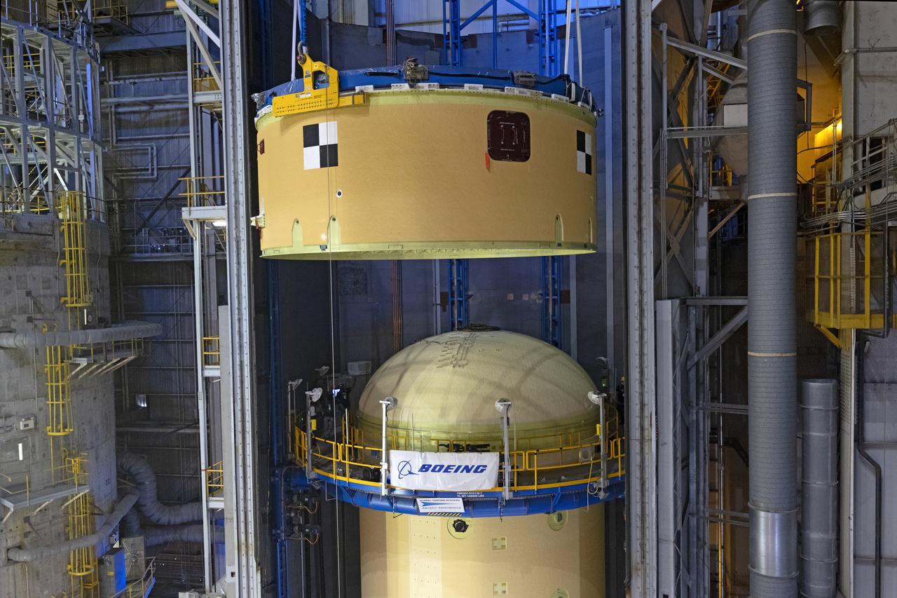 NASA’s Space Launch System (SLS) team fully stacked three hardware elements together May 24 to form the top of the rocket’s core stage for the Artemis II mission. NASA and core stage prime contractor Boeing connected the forward skirt with the liquid oxygen tank and intertank flight hardware inside an assembly area at NASA’s Michoud Assembly Facility in New Orleans. Teams had previously stacked the liquid oxygen tank and intertank on April 28. The joining of the three structures together is the first major assembly of core stage hardware for Artemis II, the first crewed Artemis mission and second flight of the SLS rocket. Next, technicians will work to complete outfitting and integrating the systems within the upper structure.   At 66 feet tall, the upper part of the stage is just a fraction of the entire core stage. The fully-assembled, 212-foot-tall rocket stage consists of five hardware elements, including two liquid propellant tanks and four RS-25 engines. The liquid oxygen tank in the upper portion of the stage will hold 196,000 gallons of liquid oxygen cooled to minus 297 degrees Fahrenheit. Meanwhile, the forward skirt and intertank house avionics, flight computer, and electronic systems for the rocket stage. Together, the core stage and its four RS-25 engines will provide more than 2 million pounds of thrust to help send Artemis II astronauts beyond Earth’s orbit to lunar orbit.   With Artemis, NASA will land the first woman and the first person of color on the Moon and establish sustainable exploration in preparation for missions to Mars. SLS and NASA’s Orion spacecraft, along with the commercial human landing system and the Gateway in orbit around the Moon, are NASA’s backbone for deep space exploration. SLS is the only rocket that can send Orion, astronauts, and supplies to the Moon in a single mission. Image credit: NASA/Michael DeMocker