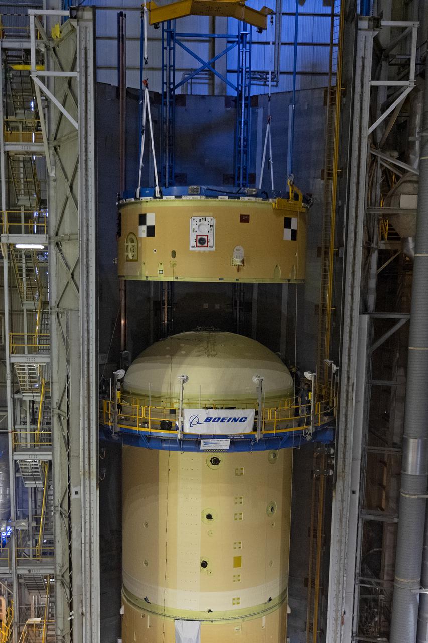 NASA’s Space Launch System (SLS) team fully stacked three hardware elements together May 24 to form the top of the rocket’s core stage for the Artemis II mission. NASA and core stage prime contractor Boeing connected the forward skirt with the liquid oxygen tank and intertank flight hardware inside an assembly area at NASA’s Michoud Assembly Facility in New Orleans. Teams had previously stacked the liquid oxygen tank and intertank on April 28. The joining of the three structures together is the first major assembly of core stage hardware for Artemis II, the first crewed Artemis mission and second flight of the SLS rocket. Next, technicians will work to complete outfitting and integrating the systems within the upper structure.   At 66 feet tall, the upper part of the stage is just a fraction of the entire core stage. The fully-assembled, 212-foot-tall rocket stage consists of five hardware elements, including two liquid propellant tanks and four RS-25 engines. The liquid oxygen tank in the upper portion of the stage will hold 196,000 gallons of liquid oxygen cooled to minus 297 degrees Fahrenheit. Meanwhile, the forward skirt and intertank house avionics, flight computer, and electronic systems for the rocket stage. Together, the core stage and its four RS-25 engines will provide more than 2 million pounds of thrust to help send Artemis II astronauts beyond Earth’s orbit to lunar orbit.   With Artemis, NASA will land the first woman and the first person of color on the Moon and establish sustainable exploration in preparation for missions to Mars. SLS and NASA’s Orion spacecraft, along with the commercial human landing system and the Gateway in orbit around the Moon, are NASA’s backbone for deep space exploration. SLS is the only rocket that can send Orion, astronauts, and supplies to the Moon in a single mission. Image credit: NASA/Michael DeMocker