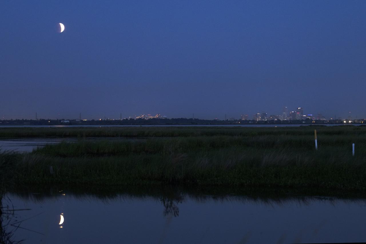 The eclipse of the Super Flower Blood Moon over Bayou Bienvenue with the skyline of the city of New Orleans in the distance early Wednesday morning, May 26, 2021. Image credit: NASA/Michael DeMocker