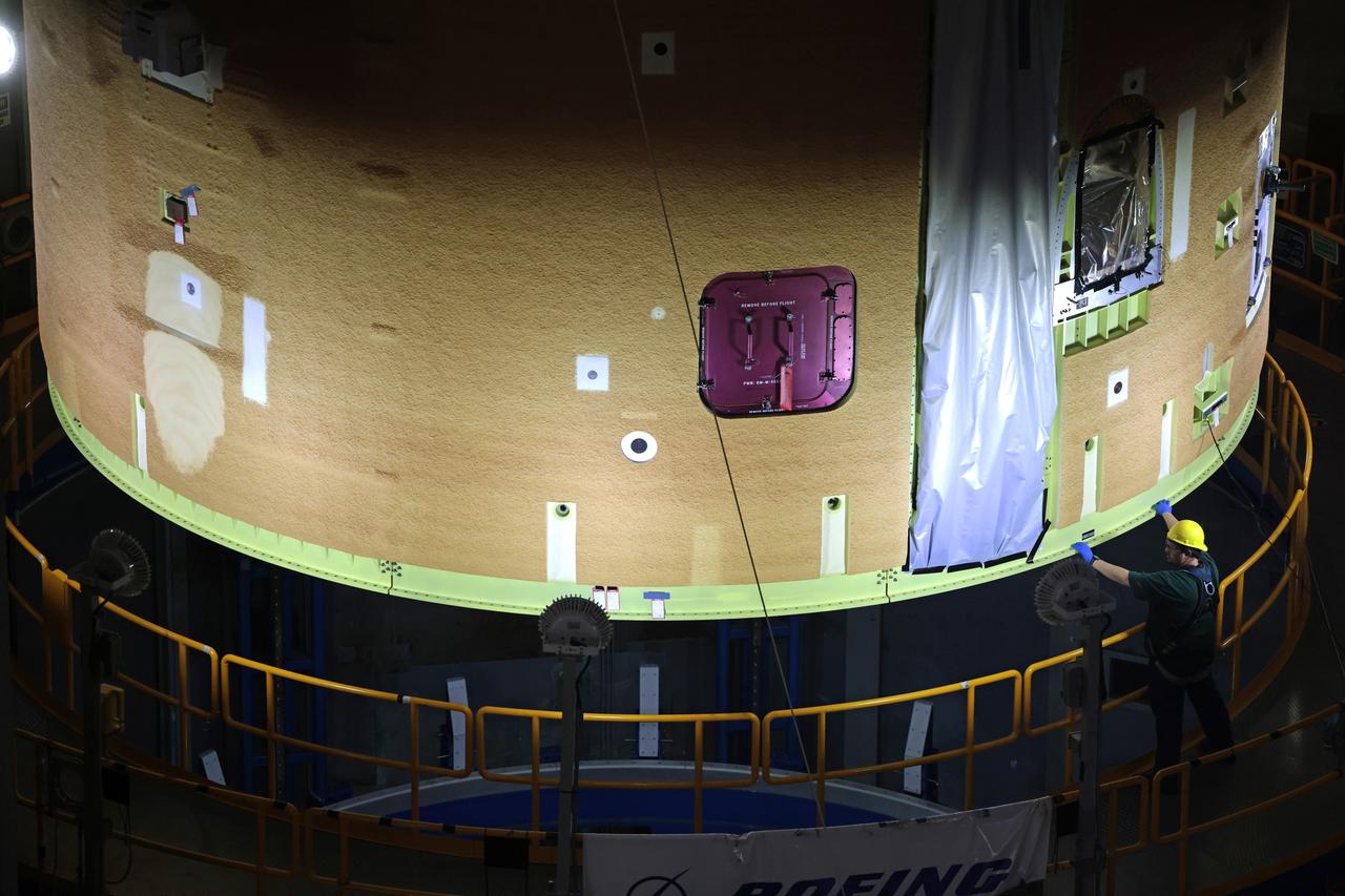 NASA has completed assembly of the upper, or forward, part of the core stage for the Space Launch System (SLS) rocket that will send the Artemis II crew on their lunar mission. Boeing, the lead core stage contractor, completed joining the forward part of the rocket, and then lifted it out of the assembly structure at NASA’s Michoud Assembly Facility in New Orleans. To construct this part of the core stage, the team first stacked three major parts of the stage—the forward skirt, the liquid oxygen tank, and the intertank. The forward skirt sits atop the rocket’s core stage, and it and the intertank are outfitted with the rocket’s flight computers and avionics systems that control SLS during launch and ascent. The liquid oxygen tank holds 196,000 gallons of liquid oxygen cooled to minus 297 degrees Fahrenheit.   The entire upper part of the stage is around 66-feet tall. The fully-assembled, 212-foot-tall rocket stage consists of five hardware elements. As the team lifted it out of the assembly area, they completed a breakover maneuver, to put the forward assembly in a horizontal position. Then, they moved it to final assembly where the Artemis II liquid hydrogen tank is also undergoing outfitting. Here, teams will connect the liquid hydrogen tank to the upper part of the rocket and complete assembly of four of the five core stage parts. The last piece to be added will be the engine section, which is currently in a separate assembly area being outfitted with propulsion systems that connect to the engines.  Image credit: NASA/Michael DeMocker