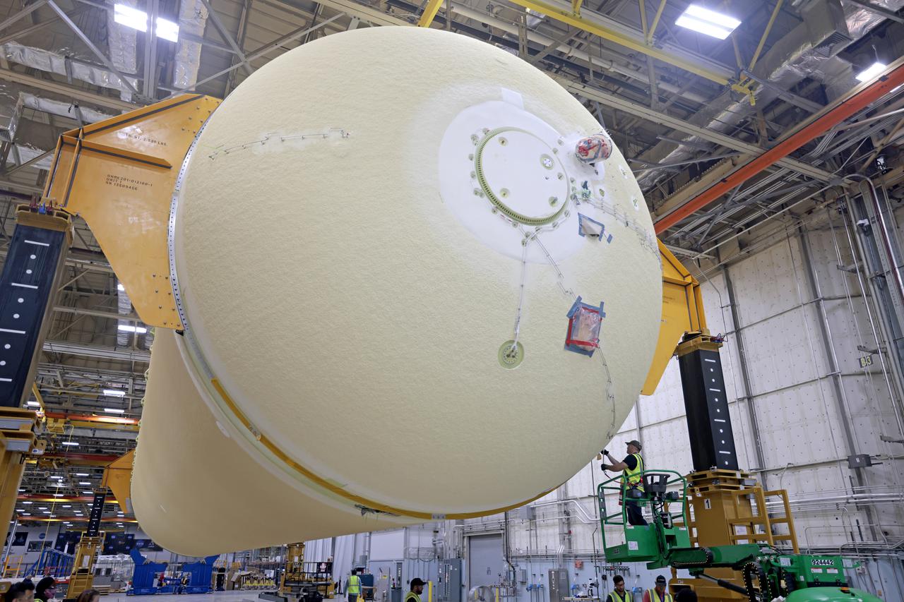 NASA is preparing major pieces of the Space Launch System rocket’s core stage to be joined as part of assembling the core stage for the Artemis II mission that will send crews to lunar orbit. Crews will soon connect the forward assembly with the 130-foot liquid hydrogen tank in the final assembly area at NASA’s Michoud Assembly Facility in New Orleans. When this process is completed, four of the five large structures that make up the core stage will be joined. The 66-foot forward assembly consists of the forward skirt, liquid oxygen tank and the intertank, which were mated earlier. This forward assembly will be joined with the 130-foot liquid hydrogen tank, the largest part of the stage that holds more than 500,000 gallons of cryogenic propellant. To compete the Artemis II core stage, engineers will add the engine section, which is currently being outfitted and includes the main propulsion systems that connect to the four RS-25 engines, Together, with the SLS twin solid rocket boosters, the core stage will produce 8.8 million pounds of thrust to send NASA’s Orion spacecraft, astronauts, and supplies beyond Earth’s orbit to the Moon. The SLS rocket and the Orion spacecraft form the foundation for deep space exploration and the Artemis lunar program.  For more on the core stage: https://www.nasa.gov/exploration/systems/sls/multimedia/infographics/corestage101.html Image credit: NASA/Michael DeMocker