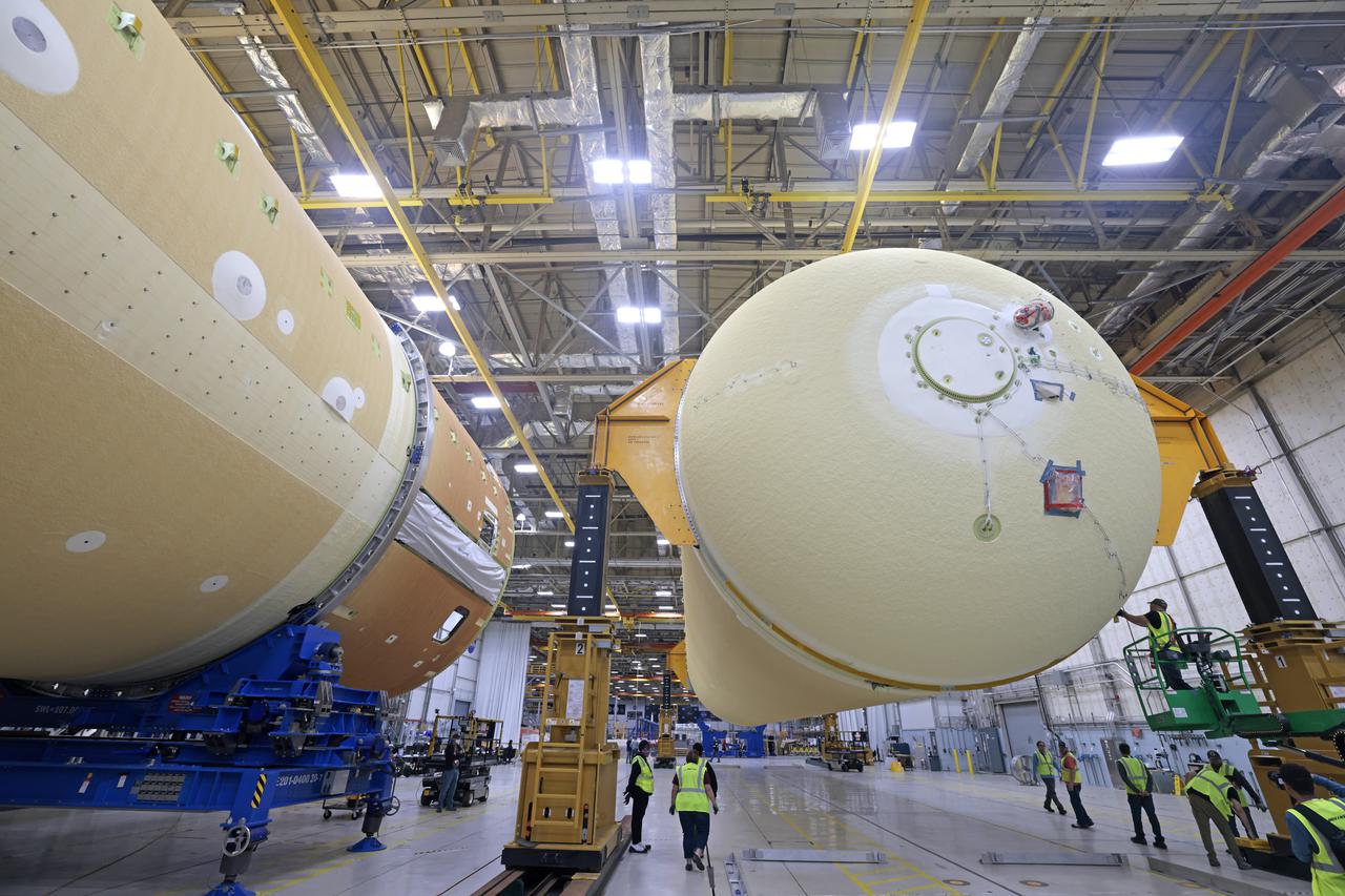 NASA is preparing major pieces of the Space Launch System rocket’s core stage to be joined as part of assembling the core stage for the Artemis II mission that will send crews to lunar orbit. Crews will soon connect the forward assembly with the 130-foot liquid hydrogen tank in the final assembly area at NASA’s Michoud Assembly Facility in New Orleans. When this process is completed, four of the five large structures that make up the core stage will be joined. The 66-foot forward assembly consists of the forward skirt, liquid oxygen tank and the intertank, which were mated earlier. This forward assembly will be joined with the 130-foot liquid hydrogen tank, the largest part of the stage that holds more than 500,000 gallons of cryogenic propellant. To compete the Artemis II core stage, engineers will add the engine section, which is currently being outfitted and includes the main propulsion systems that connect to the four RS-25 engines, Together, with the SLS twin solid rocket boosters, the core stage will produce 8.8 million pounds of thrust to send NASA’s Orion spacecraft, astronauts, and supplies beyond Earth’s orbit to the Moon. The SLS rocket and the Orion spacecraft form the foundation for deep space exploration and the Artemis lunar program.  For more on the core stage: https://www.nasa.gov/exploration/systems/sls/multimedia/infographics/corestage101.html Image credit: NASA/Michael DeMocker