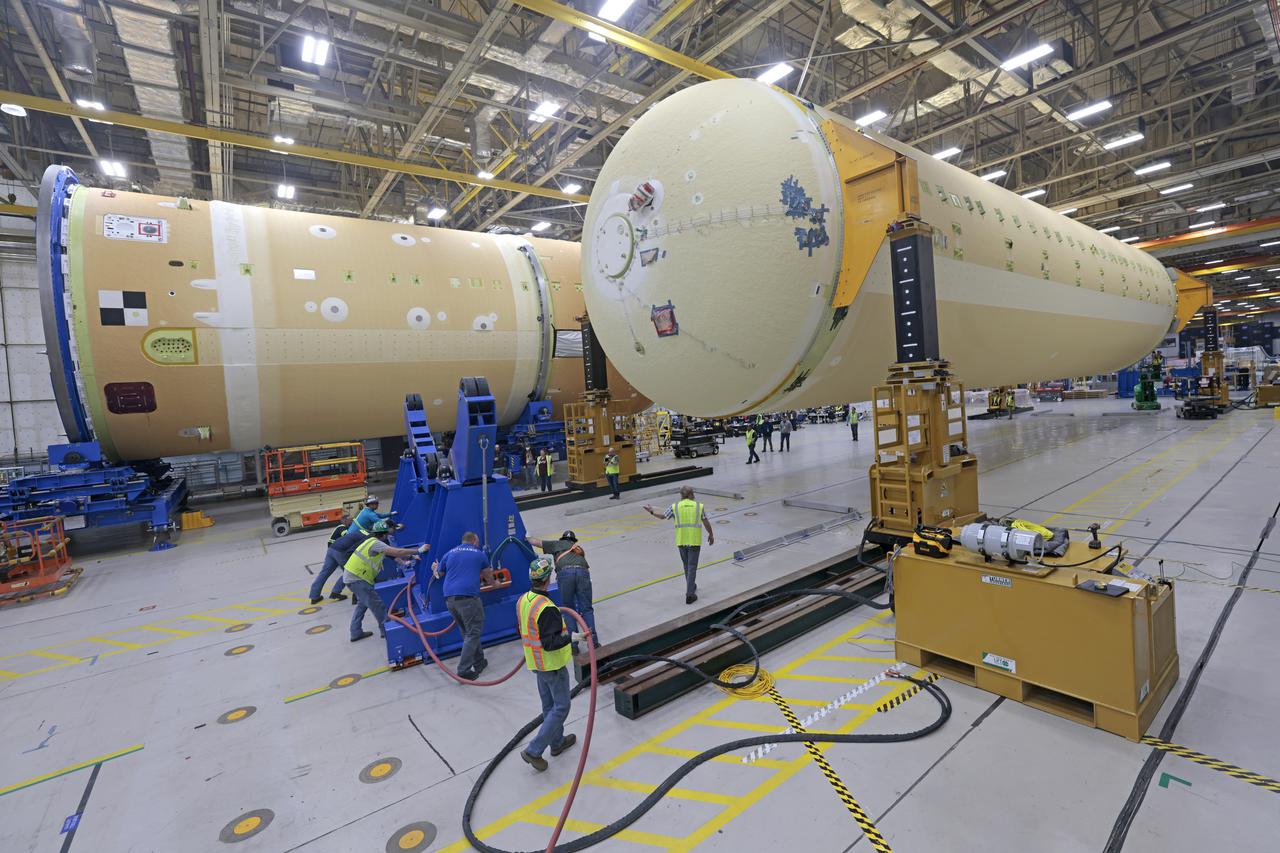 NASA is preparing major pieces of the Space Launch System rocket’s core stage to be joined as part of assembling the core stage for the Artemis II mission that will send crews to lunar orbit. Crews will soon connect the forward assembly with the 130-foot liquid hydrogen tank in the final assembly area at NASA’s Michoud Assembly Facility in New Orleans. When this process is completed, four of the five large structures that make up the core stage will be joined. The 66-foot forward assembly consists of the forward skirt, liquid oxygen tank and the intertank, which were mated earlier. This forward assembly will be joined with the 130-foot liquid hydrogen tank, the largest part of the stage that holds more than 500,000 gallons of cryogenic propellant. To compete the Artemis II core stage, engineers will add the engine section, which is currently being outfitted and includes the main propulsion systems that connect to the four RS-25 engines, Together, with the SLS twin solid rocket boosters, the core stage will produce 8.8 million pounds of thrust to send NASA’s Orion spacecraft, astronauts, and supplies beyond Earth’s orbit to the Moon. The SLS rocket and the Orion spacecraft form the foundation for deep space exploration and the Artemis lunar program.  For more on the core stage: https://www.nasa.gov/exploration/systems/sls/multimedia/infographics/corestage101.html Image credit: NASA/Michael DeMocker