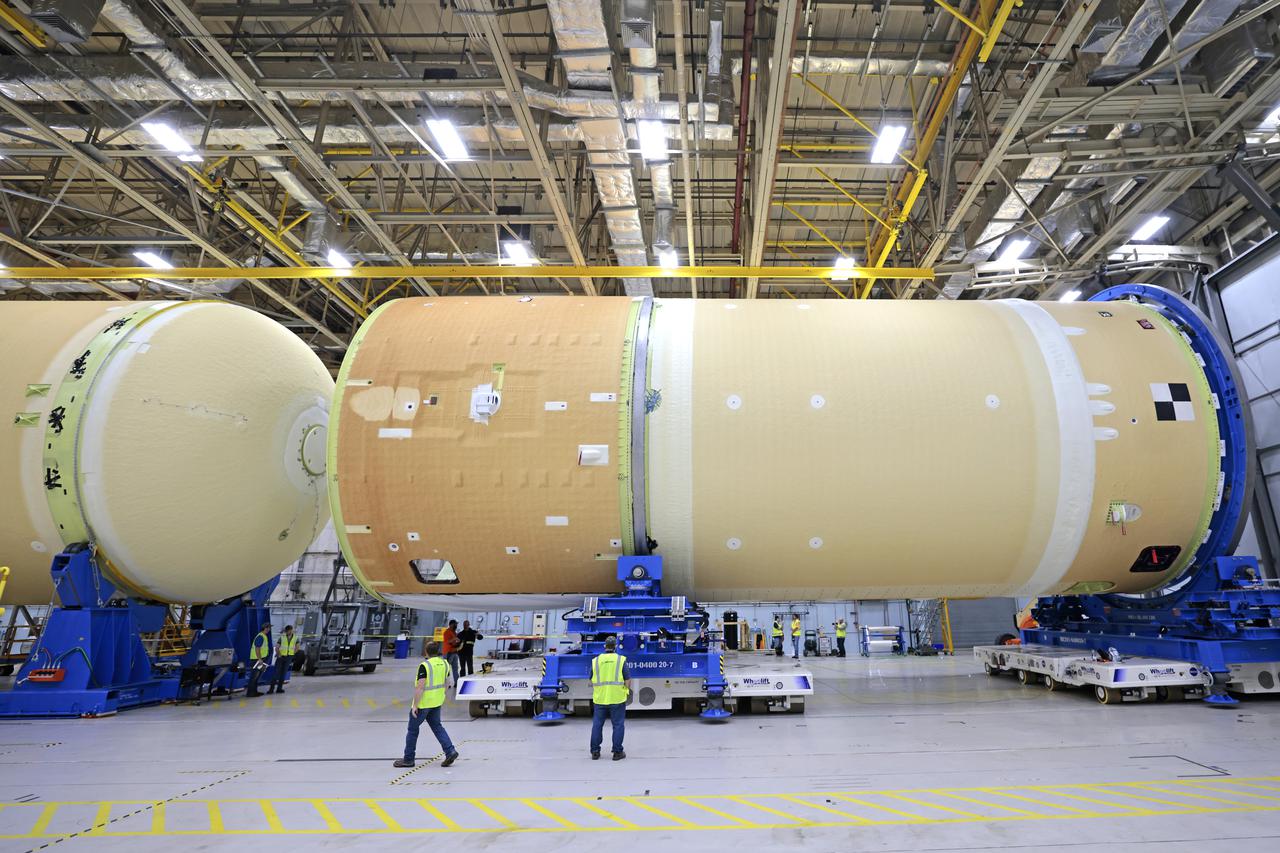 NASA is preparing major pieces of the Space Launch System rocket’s core stage to be joined as part of assembling the core stage for the Artemis II mission that will send crews to lunar orbit. Crews will soon connect the forward assembly with the 130-foot liquid hydrogen tank in the final assembly area at NASA’s Michoud Assembly Facility in New Orleans. When this process is completed, four of the five large structures that make up the core stage will be joined. The 66-foot forward assembly consists of the forward skirt, liquid oxygen tank and the intertank, which were mated earlier. This forward assembly will be joined with the 130-foot liquid hydrogen tank, the largest part of the stage that holds more than 500,000 gallons of cryogenic propellant. To compete the Artemis II core stage, engineers will add the engine section, which is currently being outfitted and includes the main propulsion systems that connect to the four RS-25 engines, Together, with the SLS twin solid rocket boosters, the core stage will produce 8.8 million pounds of thrust to send NASA’s Orion spacecraft, astronauts, and supplies beyond Earth’s orbit to the Moon. The SLS rocket and the Orion spacecraft form the foundation for deep space exploration and the Artemis lunar program.  For more on the core stage: https://www.nasa.gov/exploration/systems/sls/multimedia/infographics/corestage101.html Image credit: NASA/Michael DeMocker