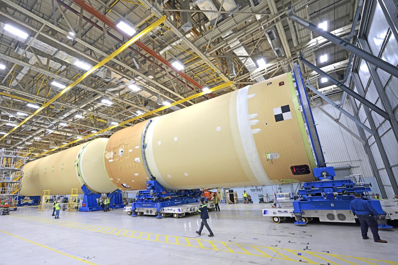 NASA is preparing major pieces of the Space Launch System rocket’s core stage to be joined as part of assembling the core stage for the Artemis II mission that will send crews to lunar orbit. Crews will soon connect the forward assembly with the 130-foot liquid hydrogen tank in the final assembly area at NASA’s Michoud Assembly Facility in New Orleans. When this process is completed, four of the five large structures that make up the core stage will be joined. The 66-foot forward assembly consists of the forward skirt, liquid oxygen tank and the intertank, which were mated earlier. This forward assembly will be joined with the 130-foot liquid hydrogen tank, the largest part of the stage that holds more than 500,000 gallons of cryogenic propellant. To compete the Artemis II core stage, engineers will add the engine section, which is currently being outfitted and includes the main propulsion systems that connect to the four RS-25 engines, Together, with the SLS twin solid rocket boosters, the core stage will produce 8.8 million pounds of thrust to send NASA’s Orion spacecraft, astronauts, and supplies beyond Earth’s orbit to the Moon. The SLS rocket and the Orion spacecraft form the foundation for deep space exploration and the Artemis lunar program.  For more on the core stage: https://www.nasa.gov/exploration/systems/sls/multimedia/infographics/corestage101.html Image credit: NASA/Michael DeMocker