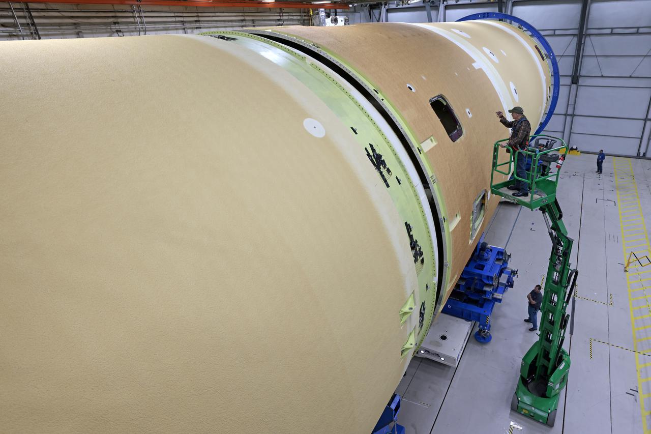 NASA joined the Space Launch System rocket’s core stage forward assembly with the 130-foot liquid hydrogen tank for the Artemis II mission on March 18. This completes assembly of four of the five large structures that make up the core stage that will help send the first astronauts to lunar orbit on Artemis II. The 66-foot forward assembly consists of the forward skirt, liquid oxygen tank and the intertank, which were mated earlier. Engineers inserted 360 bolts to connect the forward assembly to the liquid hydrogen tank to make up the bulk of the stage. Only the engine section, which is currently being outfitted and includes the main propulsion systems that connect to the four RS-25 engines, remains to be added to form the final core stage. All parts of the core stage are manufactured by NASA and Boeing, the core stage lead contractor at the agency’s Michoud Assembly Facility in New Orleans. Currently, the team is building core stages for three Artemis missions. The first core stage is stacked with the rest of the SLS rocket, which will launch the Artemis I mission to the Moon this year. Together with its twin solid rocket boosters, the core stage will produce 8.8 million pounds of thrust to send NASA’s Orion spacecraft, astronauts, and supplies beyond Earth’s orbit to the Moon. The SLS rocket and the Orion spacecraft form the foundation for Artemis missions and future deep space exploration. Image credit: NASA/Michael DeMocker