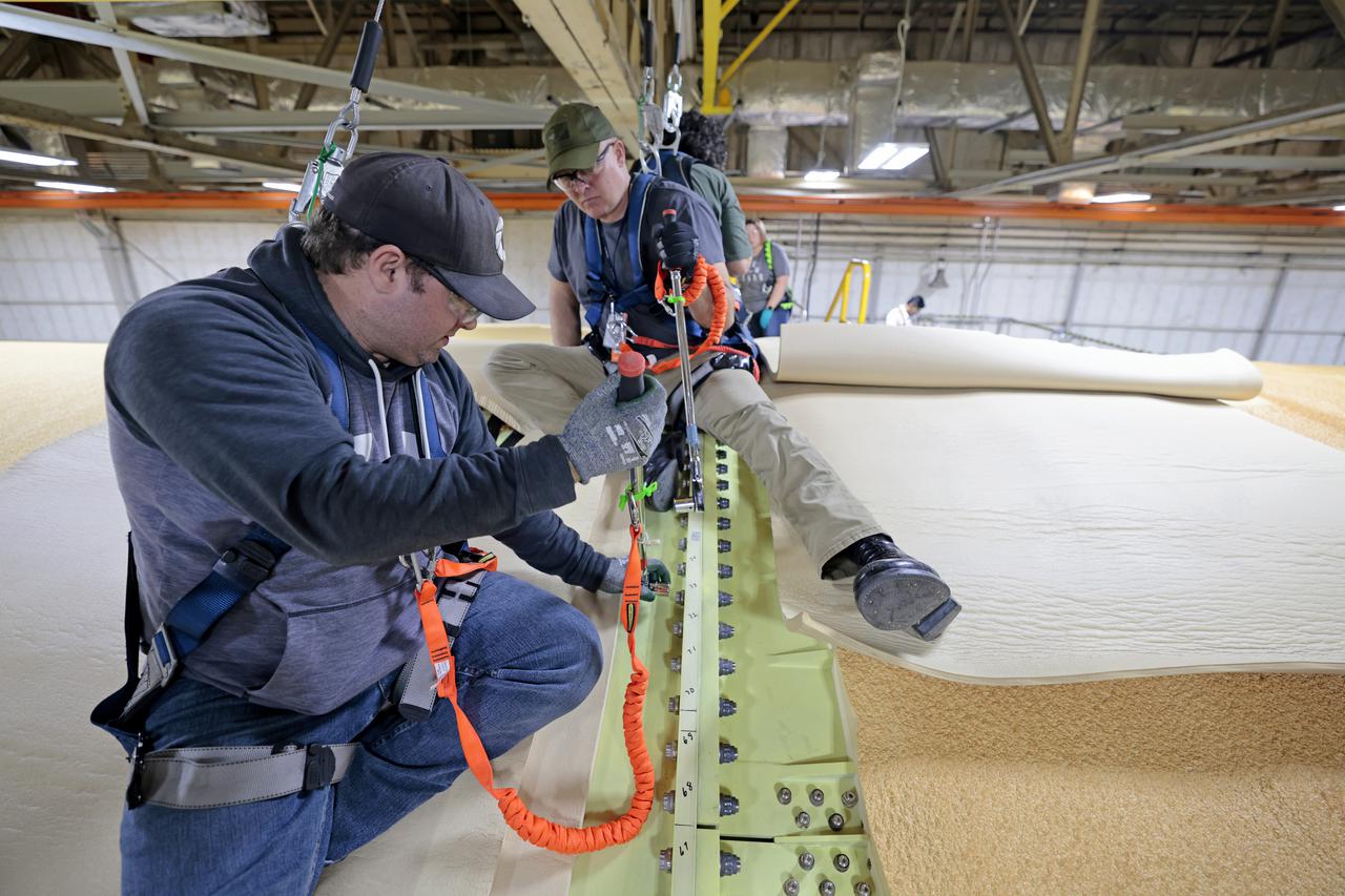 NASA joined the Space Launch System rocket’s core stage forward assembly with the 130-foot liquid hydrogen tank for the Artemis II mission on March 18. This completes assembly of four of the five large structures that make up the core stage that will help send the first astronauts to lunar orbit on Artemis II. The 66-foot forward assembly consists of the forward skirt, liquid oxygen tank and the intertank, which were mated earlier. Engineers inserted 360 bolts to connect the forward assembly to the liquid hydrogen tank to make up the bulk of the stage. Only the engine section, which is currently being outfitted and includes the main propulsion systems that connect to the four RS-25 engines, remains to be added to form the final core stage. All parts of the core stage are manufactured by NASA and Boeing, the core stage lead contractor at the agency’s Michoud Assembly Facility in New Orleans. Currently, the team is building core stages for three Artemis missions. The first core stage is stacked with the rest of the SLS rocket, which will launch the Artemis I mission to the Moon this year. Together with its twin solid rocket boosters, the core stage will produce 8.8 million pounds of thrust to send NASA’s Orion spacecraft, astronauts, and supplies beyond Earth’s orbit to the Moon. The SLS rocket and the Orion spacecraft form the foundation for Artemis missions and future deep space exploration. Image credit: NASA/Michael DeMocker