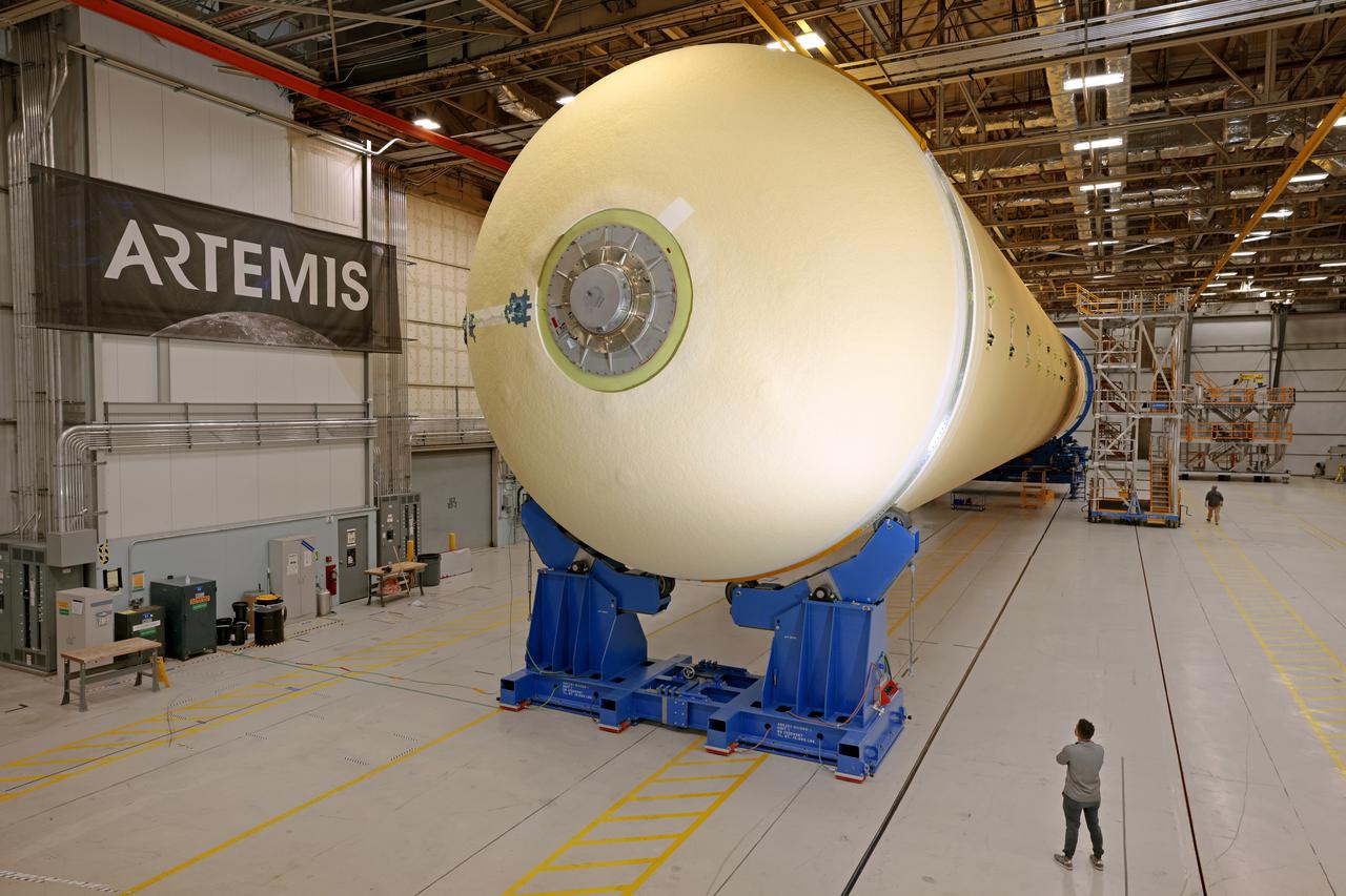 NASA joined the Space Launch System rocket’s core stage forward assembly with the 130-foot liquid hydrogen tank for the Artemis II mission on March 18. This completes assembly of four of the five large structures that make up the core stage that will help send the first astronauts to lunar orbit on Artemis II. The 66-foot forward assembly consists of the forward skirt, liquid oxygen tank and the intertank, which were mated earlier. Engineers inserted 360 bolts to connect the forward assembly to the liquid hydrogen tank to make up the bulk of the stage. Only the engine section, which is currently being outfitted and includes the main propulsion systems that connect to the four RS-25 engines, remains to be added to form the final core stage. All parts of the core stage are manufactured by NASA and Boeing, the core stage lead contractor at the agency’s Michoud Assembly Facility in New Orleans. Currently, the team is building core stages for three Artemis missions. The first core stage is stacked with the rest of the SLS rocket, which will launch the Artemis I mission to the Moon this year. Together with its twin solid rocket boosters, the core stage will produce 8.8 million pounds of thrust to send NASA’s Orion spacecraft, astronauts, and supplies beyond Earth’s orbit to the Moon. The SLS rocket and the Orion spacecraft form the foundation for Artemis missions and future deep space exploration. Image credit: NASA/Michael DeMocker