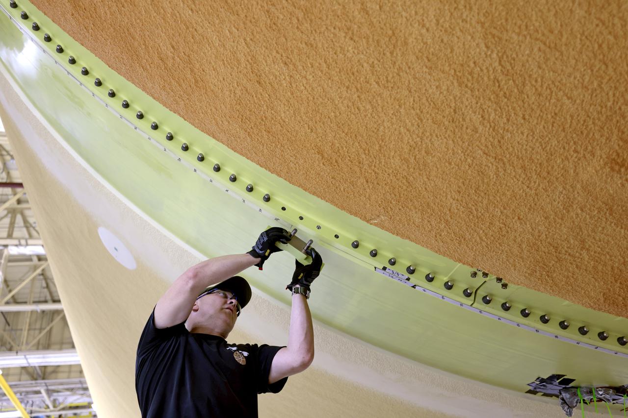 NASA joined the Space Launch System rocket’s core stage forward assembly with the 130-foot liquid hydrogen tank for the Artemis II mission on March 18. This completes assembly of four of the five large structures that make up the core stage that will help send the first astronauts to lunar orbit on Artemis II. The 66-foot forward assembly consists of the forward skirt, liquid oxygen tank and the intertank, which were mated earlier. Engineers inserted 360 bolts to connect the forward assembly to the liquid hydrogen tank to make up the bulk of the stage. Only the engine section, which is currently being outfitted and includes the main propulsion systems that connect to the four RS-25 engines, remains to be added to form the final core stage. All parts of the core stage are manufactured by NASA and Boeing, the core stage lead contractor at the agency’s Michoud Assembly Facility in New Orleans. Currently, the team is building core stages for three Artemis missions. The first core stage is stacked with the rest of the SLS rocket, which will launch the Artemis I mission to the Moon this year. Together with its twin solid rocket boosters, the core stage will produce 8.8 million pounds of thrust to send NASA’s Orion spacecraft, astronauts, and supplies beyond Earth’s orbit to the Moon. The SLS rocket and the Orion spacecraft form the foundation for Artemis missions and future deep space exploration. Image credit: NASA/Michael DeMocker