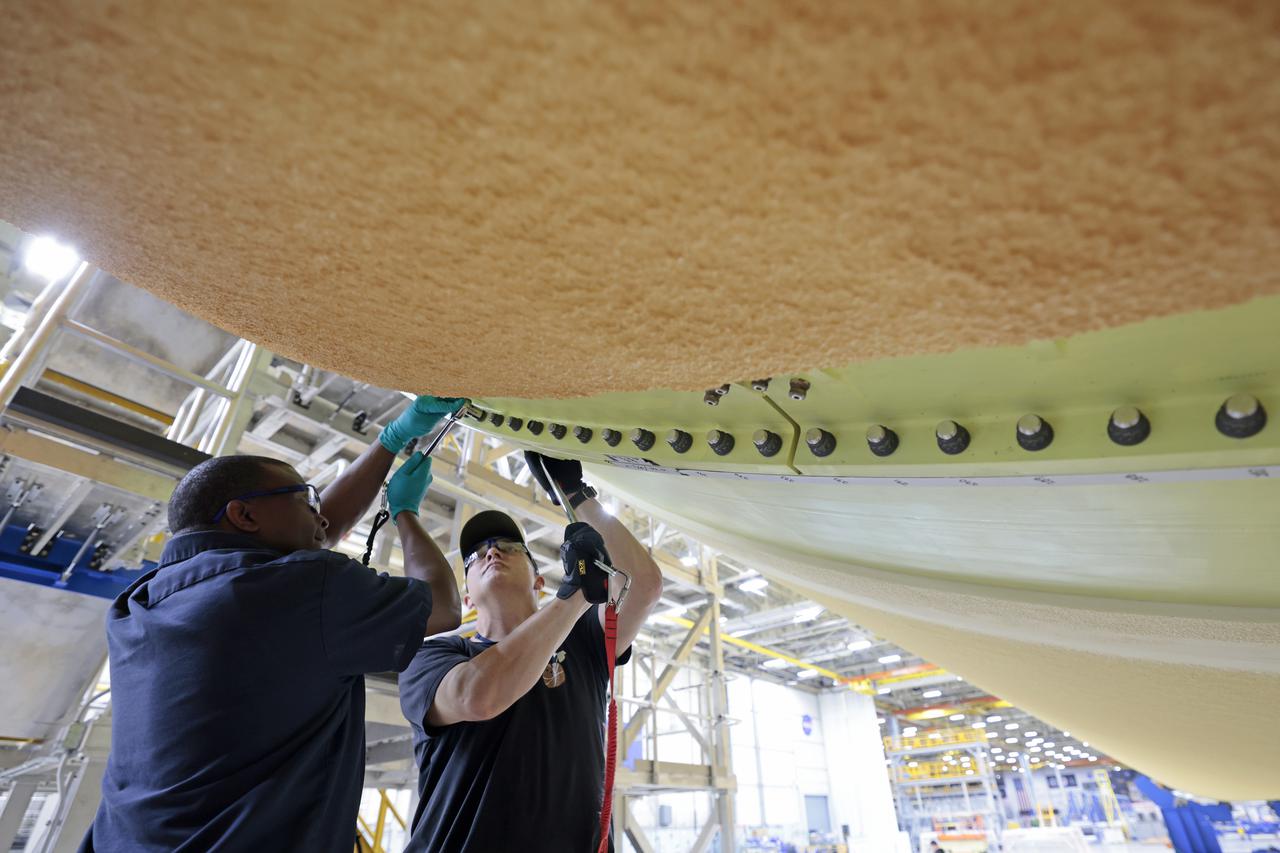 NASA joined the Space Launch System rocket’s core stage forward assembly with the 130-foot liquid hydrogen tank for the Artemis II mission on March 18. This completes assembly of four of the five large structures that make up the core stage that will help send the first astronauts to lunar orbit on Artemis II. The 66-foot forward assembly consists of the forward skirt, liquid oxygen tank and the intertank, which were mated earlier. Engineers inserted 360 bolts to connect the forward assembly to the liquid hydrogen tank to make up the bulk of the stage. Only the engine section, which is currently being outfitted and includes the main propulsion systems that connect to the four RS-25 engines, remains to be added to form the final core stage. All parts of the core stage are manufactured by NASA and Boeing, the core stage lead contractor at the agency’s Michoud Assembly Facility in New Orleans. Currently, the team is building core stages for three Artemis missions. The first core stage is stacked with the rest of the SLS rocket, which will launch the Artemis I mission to the Moon this year. Together with its twin solid rocket boosters, the core stage will produce 8.8 million pounds of thrust to send NASA’s Orion spacecraft, astronauts, and supplies beyond Earth’s orbit to the Moon. The SLS rocket and the Orion spacecraft form the foundation for Artemis missions and future deep space exploration. Image credit: NASA/Michael DeMocker