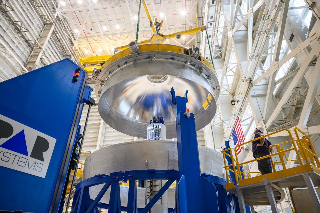 These images show technicians at NASA’s Michoud Assembly Facility in New Orleans lifting and installing the liquid oxygen dome weld confidence article for a future upper stage for NASA’s SLS (Space Launch System) rocket onto the LTAC (LOX Tank Assembly Center) in Building 115 at Michoud for the next phase of manufacturing in July 2023.  The dome makes up a portion of the liquid oxygen tank weld confidence article for the EUS (exploration upper stage). Teams use weld confidence articles to verify welding procedures and structural integrity of the welds to manufacture structural test and flight versions of the hardware.  EUS flight hardware is in early production at Michoud. The more powerful upper stage and its four RL10 engines will be used on the second configuration of the SLS rocket, known as Block 1B, and will provide in-space propulsion to send astronauts in NASA’s Orion spacecraft and heavy cargo on a precise trajectory to the Moon. NASA and Boeing, the lead contractor for the SLS core stage and EUS, are manufacturing SLS stages for Artemis II, III, IV, and V at the facility.   NASA is working to land the first woman and first person of color on the Moon under Artemis. SLS is part of NASA’s backbone for deep space exploration, along with Orion and the Gateway in orbit around the Moon. SLS is the only rocket that can send Orion, astronauts, and supplies to the Moon in a single mission. 