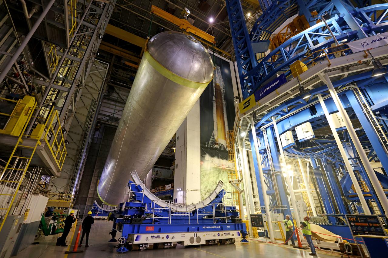 These photos show how teams moved and prepared a liquid hydrogen tank for the SLS (Space Launch System) rocket for priming in the Vertical Assembly Building at NASA’s Michoud Assembly Facility in New Orleans Nov. 14, 2023. The hardware will form part of the core stage for the SLS rocket that will power Artemis III. To prepare the flight hardware for primer, the tank underwent internal cleaning in nearby Cell E in October. Internal cleaning is part of the manufacturing process for the core stage. After testing, both of the stage’s propellant tanks and its dry structures – the elements that do not hold fuel – are cleaned, primed, and readied for the next phase of production Technichians will next sand down and prepare the surface of the tank before coating it in a primer. Primer is applied to the barrel section of the tank by an automated robotic tool, whereas the forward and aft domes are primed manually.  The propellant tank is the largest of the five major elements that make up the 212-foot-tall Moon rocket stage. The core stage, along with its four RS-25 engines, produce two million pounds of thrust to help launch NASA’s Orion spacecraft, astronauts, and supplies beyond Earth’s orbit and to the lunar surface for Artemis.  Image credit: NASA/Michael DeMocker