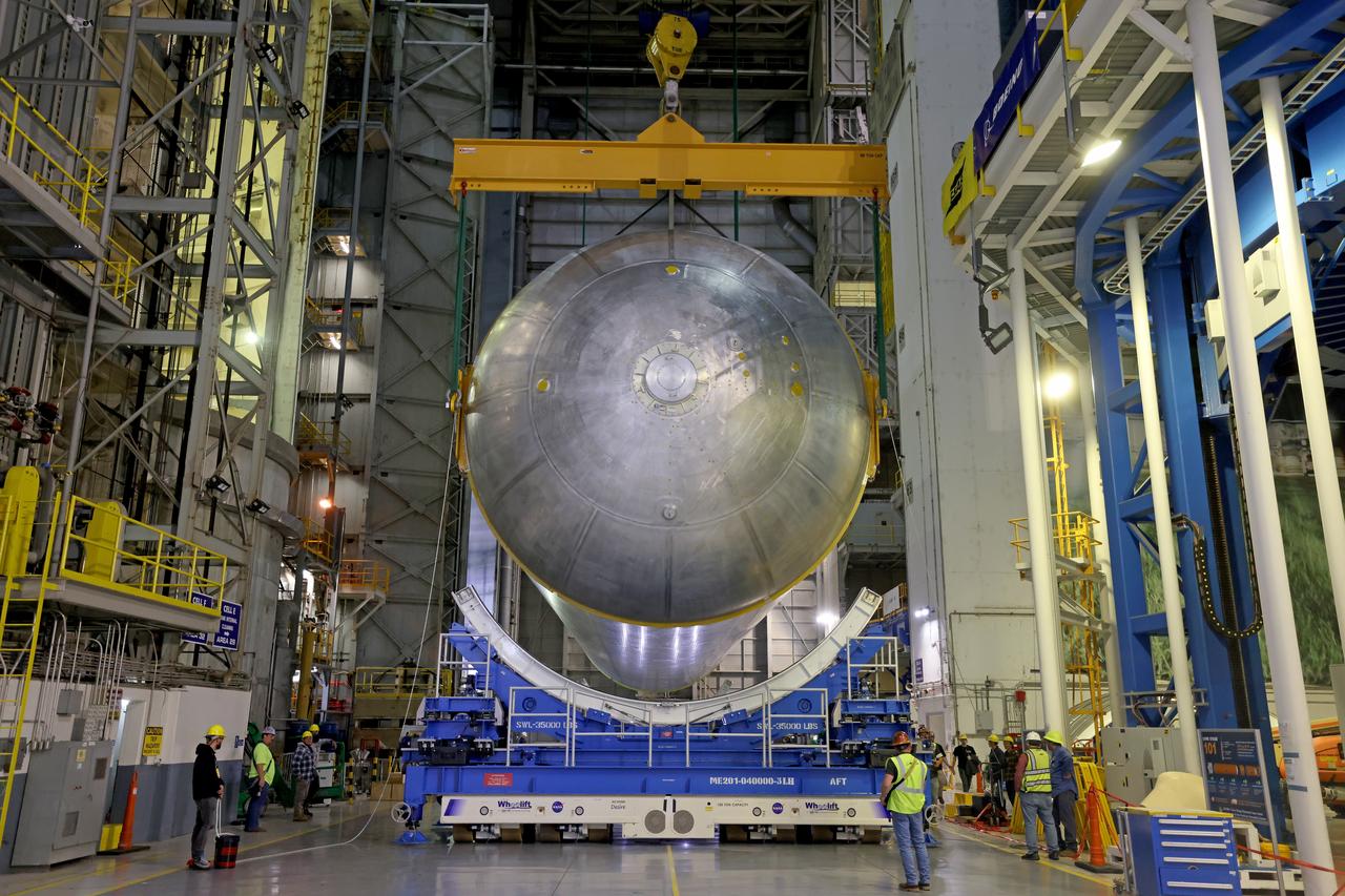 These photos show how teams moved and prepared a liquid hydrogen tank for the SLS (Space Launch System) rocket for priming in the Vertical Assembly Building at NASA’s Michoud Assembly Facility in New Orleans Nov. 14, 2023. The hardware will form part of the core stage for the SLS rocket that will power Artemis III. To prepare the flight hardware for primer, the tank underwent internal cleaning in nearby Cell E in October. Internal cleaning is part of the manufacturing process for the core stage. After testing, both of the stage’s propellant tanks and its dry structures – the elements that do not hold fuel – are cleaned, primed, and readied for the next phase of production Technichians will next sand down and prepare the surface of the tank before coating it in a primer. Primer is applied to the barrel section of the tank by an automated robotic tool, whereas the forward and aft domes are primed manually.  The propellant tank is the largest of the five major elements that make up the 212-foot-tall Moon rocket stage. The core stage, along with its four RS-25 engines, produce two million pounds of thrust to help launch NASA’s Orion spacecraft, astronauts, and supplies beyond Earth’s orbit and to the lunar surface for Artemis.  Image credit: NASA/Michael DeMocker