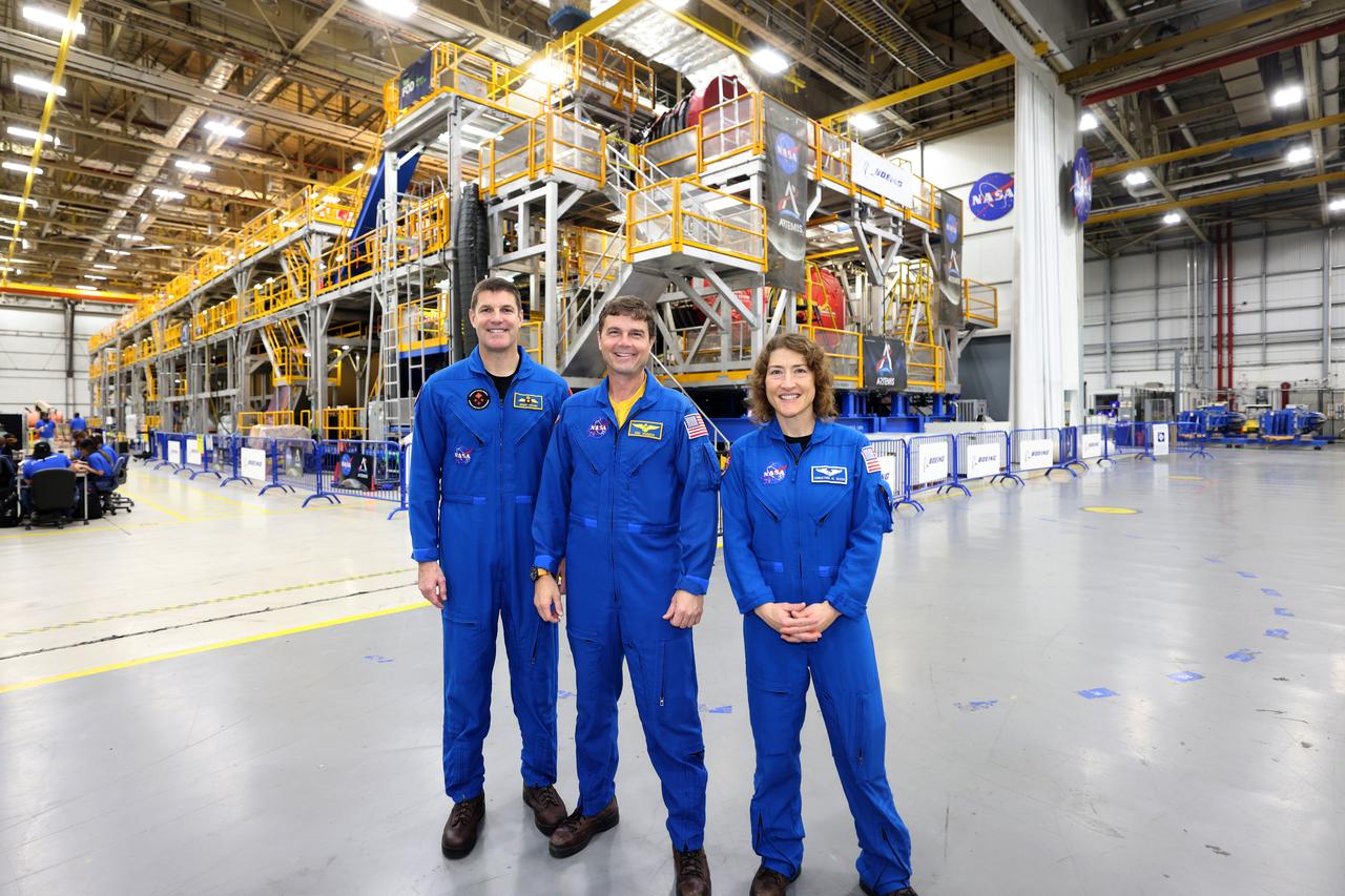 Artemis II NASA astronauts Reid Wiseman and Christina Koch of NASA and CSA (Canadian Space Agency) astronaut Jeremy Hansen view the core stage for the SLS (Space Launch System) rocket at the agency’s Michoud Assembly Facility in New Orleans on Nov. 16. The three astronauts, along with NASA’s Victor Glover, will launch atop the rocket stage to venture around the Moon on Artemis II, the first crewed flight for Artemis. The SLS core stage, towering at 212 feet, is the backbone of the Moon rocket and includes two massive propellant tanks that collectively hold 733,000 gallons of propellant to help power the stage’s four RS-25 engines. NASA is working to land the first woman and first person of color on the Moon under Artemis. SLS is part of NASA’s backbone for deep space exploration, along with Orion and the Gateway in orbit around the Moon. SLS is the only rocket that can send Orion, astronauts, and supplies to the Moon in a single mission.
