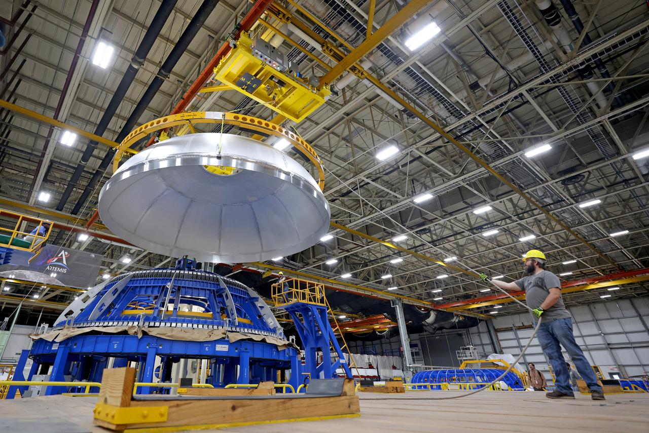 This imagery shows how technicians at NASA’s Michoud Assembly Facility moved the aft dome of the liquid oxygen tank for NASA’s SLS (Space Launch System) rocket for the next phase of production inside the Vertical Assembly center Dec. 5. The dome will form part of the core stage that will power NASA’s Artemis III mission. Engineers will soon rotate the dome to attach it to the previously joined forward dome and aft barrel segments using friction-stir welding.  The liquid oxygen tank is one of five major components that make up the SLS rocket’s core stage. Together with the forward skirt, intertank, liquid hydrogen tank, engine section, along with the four RS-25 engines at its base, the 212-foot core stage will help power NASA’s Artemis missions to the Moon.  Image credit: NASA/Michael DeMocker