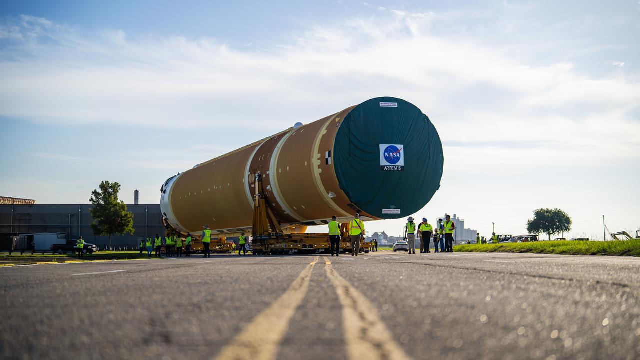 These images and videos show team members moving the first core stage that will help launch the first crewed flight of NASA’s SLS (Space Launch System) rocket for the agency’s Artemis II mission. The move marked the first time a fully assembled Moon rocket stage for a crewed mission has rolled out from NASA’s Michoud Assembly Facility in New Orleans since the Apollo Program, The core stage was moved onto the agency’s Pegasus barge, where it will be ferried to NASA’s Kennedy Space Center in Florida.  The core stage for the SLS mega rocket is the largest stage NASA has ever produced. At 212 feet tall, the stage consists of five major elements, including two huge propellant tanks that collectively hold more than 733,000 gallons of super chilled liquid propellant to feed four RS-25 engines at its base. During launch and flight, the stage will operate for just over eight minutes, producing more than 2 million pounds of thrust to help send a crew of four astronauts inside NASA’s Orion spacecraft onward to the Moon.  NASA is working to land the first woman, first person of color, and its first international partner astronaut on the Moon under Artemis. SLS is part of NASA’s backbone for deep space exploration, along with the Orion spacecraft and Gateway in orbit around the Moon and commercial human landing systems, next-generation space, next-generational spacesuits, and rovers on the lunar surface. SLS is the only rocket that can send Orion, astronauts, and supplies to the Moon in a single launch. 