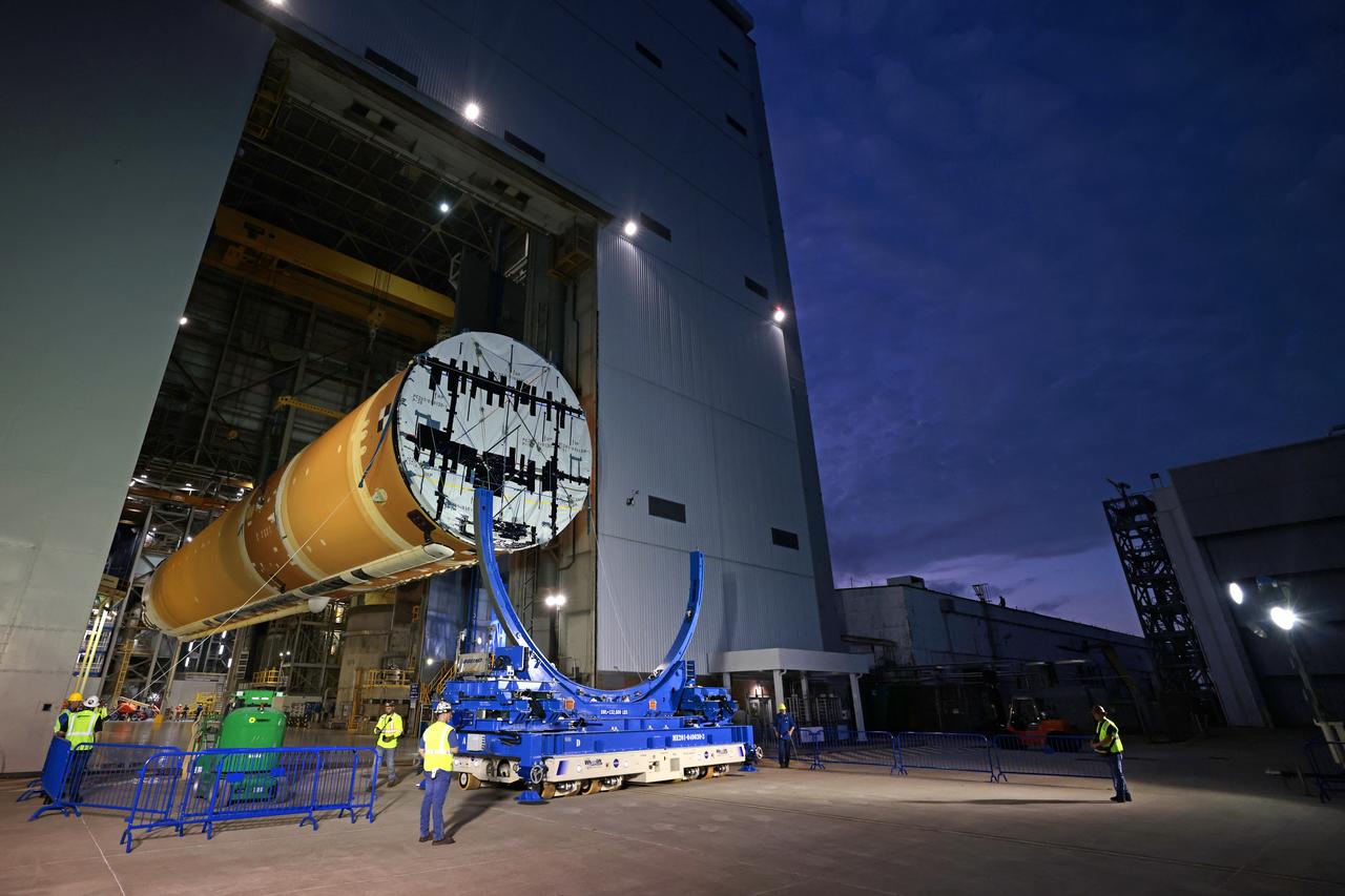 Technicians at Michoud Assembly Facility in New Orleans lift the core stage that will help launch the first crewed flight of NASA’s SLS (Space Launch System) rocket for the agency’s Artemis II mission. Teams at Michoud lifted the core stage on Thursday, July 11, 2024, onto NASA’s Multi-Purpose Transportation System, designed to transport SLS vehicle segments by waterway and roadway. It is tasked with transporting the vehicle from where it is manufactured to its intermediate test location and final launch destination. The core stage was lifted in preparation for its move onto the agency’s Pegasus barge, where it will be ferried to NASA’s Kennedy Space Center in Florida. Pegasus is maintained at Michoud. The core stage for the SLS mega rocket is the largest stage NASA has ever produced. At 212 feet tall, the stage consists of five major elements, including two huge propellant tanks that collectively hold more than 733,000 gallons of super chilled liquid propellant to feed four RS-25 engines at its base. During launch and flight, the stage will operate for just over eight minutes, producing more than 2 million pounds of thrust to help send a crew of four astronauts inside NASA’s Orion spacecraft onward to the Moon. All the major structures for every SLS core stage are fully manufactured at NASA Michoud.  NASA is working to land the first woman, first person of color, and its first international partner astronaut on the Moon under Artemis. SLS is part of NASA’s backbone for deep space exploration, along with the Orion spacecraft and Gateway in orbit around the Moon and commercial human landing systems, next-generation space, next-generational spacesuits, and rovers on the lunar surface. SLS is the only rocket that can send Orion, astronauts, and supplies to the Moon in a single launch. Image credit: NASA/Michael DeMocker