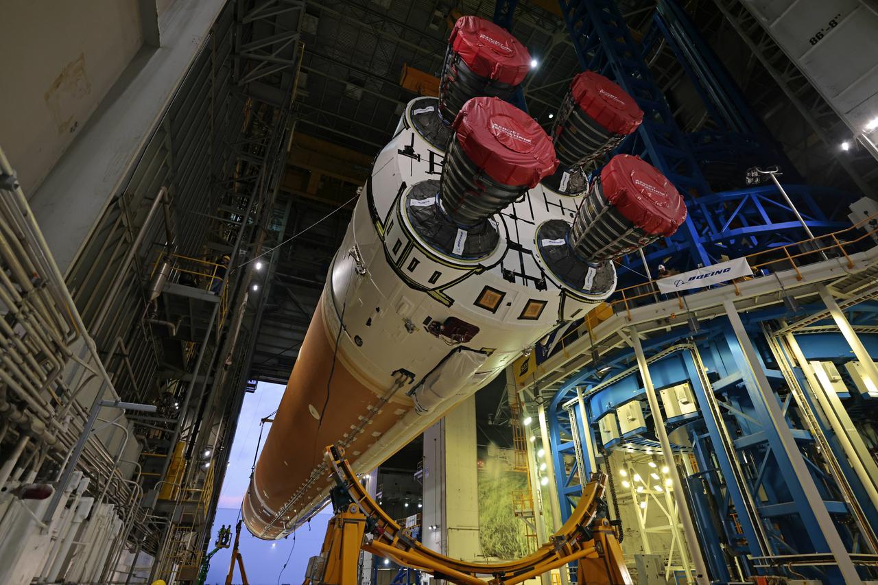 Technicians at Michoud Assembly Facility in New Orleans lift the core stage that will help launch the first crewed flight of NASA’s SLS (Space Launch System) rocket for the agency’s Artemis II mission. Teams at Michoud lifted the core stage on Thursday, July 11, 2024, onto NASA’s Multi-Purpose Transportation System, designed to transport SLS vehicle segments by waterway and roadway. It is tasked with transporting the vehicle from where it is manufactured to its intermediate test location and final launch destination. The core stage was lifted in preparation for its move onto the agency’s Pegasus barge, where it will be ferried to NASA’s Kennedy Space Center in Florida. Pegasus is maintained at Michoud. The core stage for the SLS mega rocket is the largest stage NASA has ever produced. At 212 feet tall, the stage consists of five major elements, including two huge propellant tanks that collectively hold more than 733,000 gallons of super chilled liquid propellant to feed four RS-25 engines at its base. During launch and flight, the stage will operate for just over eight minutes, producing more than 2 million pounds of thrust to help send a crew of four astronauts inside NASA’s Orion spacecraft onward to the Moon. All the major structures for every SLS core stage are fully manufactured at NASA Michoud.  NASA is working to land the first woman, first person of color, and its first international partner astronaut on the Moon under Artemis. SLS is part of NASA’s backbone for deep space exploration, along with the Orion spacecraft and Gateway in orbit around the Moon and commercial human landing systems, next-generation space, next-generational spacesuits, and rovers on the lunar surface. SLS is the only rocket that can send Orion, astronauts, and supplies to the Moon in a single launch. Image credit: NASA/Michael DeMocker
