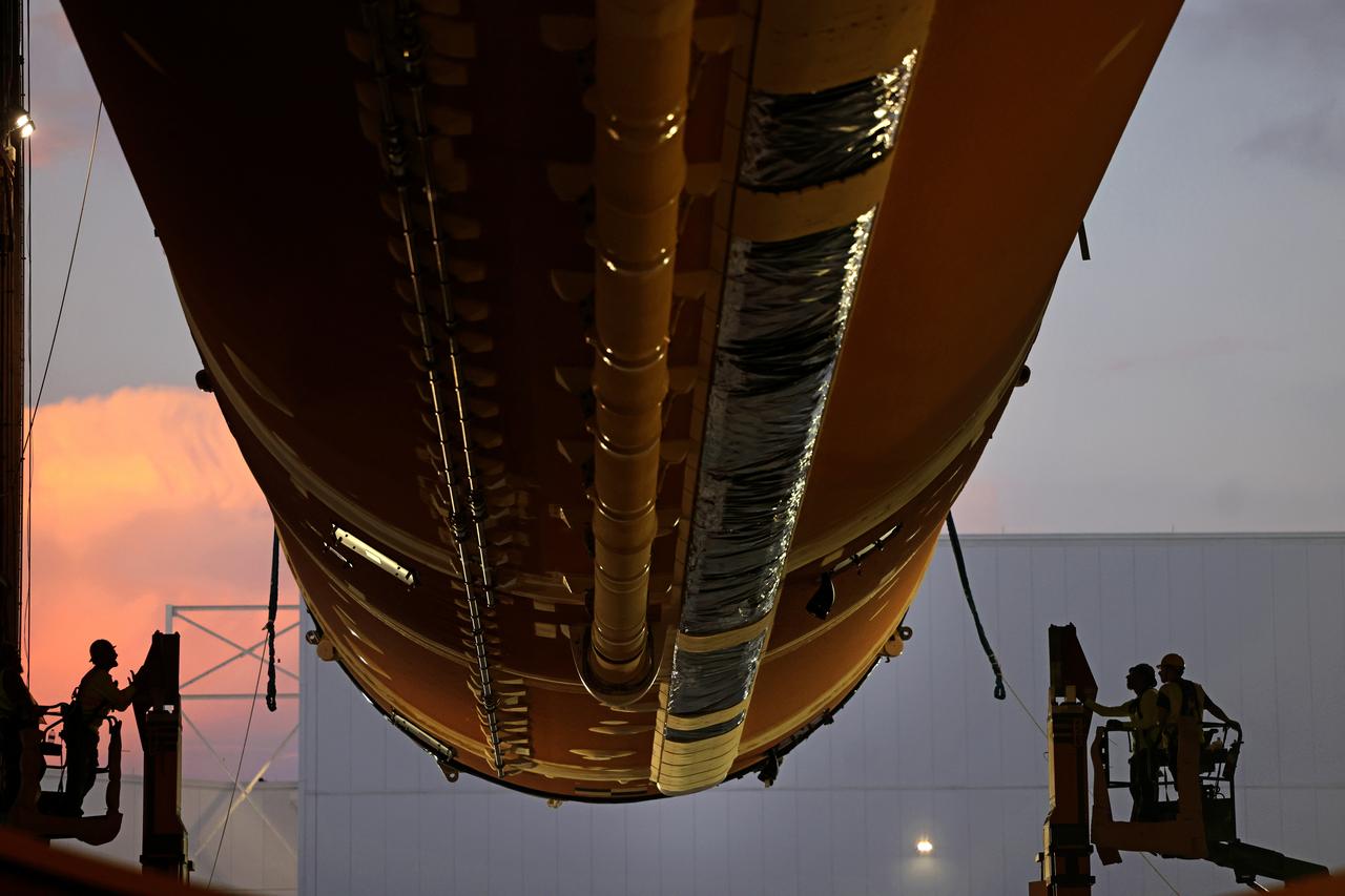Technicians at Michoud Assembly Facility in New Orleans lift the core stage that will help launch the first crewed flight of NASA’s SLS (Space Launch System) rocket for the agency’s Artemis II mission. Teams at Michoud lifted the core stage on Thursday, July 11, 2024, onto NASA’s Multi-Purpose Transportation System, designed to transport SLS vehicle segments by waterway and roadway. It is tasked with transporting the vehicle from where it is manufactured to its intermediate test location and final launch destination. The core stage was lifted in preparation for its move onto the agency’s Pegasus barge, where it will be ferried to NASA’s Kennedy Space Center in Florida. Pegasus is maintained at Michoud. The core stage for the SLS mega rocket is the largest stage NASA has ever produced. At 212 feet tall, the stage consists of five major elements, including two huge propellant tanks that collectively hold more than 733,000 gallons of super chilled liquid propellant to feed four RS-25 engines at its base. During launch and flight, the stage will operate for just over eight minutes, producing more than 2 million pounds of thrust to help send a crew of four astronauts inside NASA’s Orion spacecraft onward to the Moon. All the major structures for every SLS core stage are fully manufactured at NASA Michoud.  NASA is working to land the first woman, first person of color, and its first international partner astronaut on the Moon under Artemis. SLS is part of NASA’s backbone for deep space exploration, along with the Orion spacecraft and Gateway in orbit around the Moon and commercial human landing systems, next-generation space, next-generational spacesuits, and rovers on the lunar surface. SLS is the only rocket that can send Orion, astronauts, and supplies to the Moon in a single launch. Image credit: NASA/Michael DeMocker