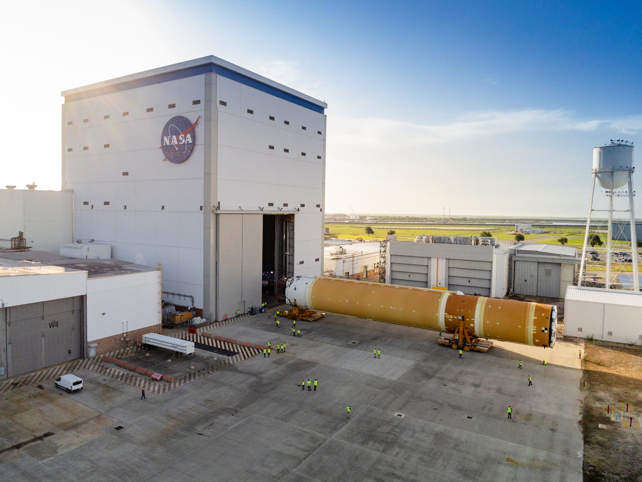 This photo shows NASA and Boeing, the SLS core stage lead contractor, preparing the SLS (Space Launch System) rocket core stage for shipment at NASA’s Michoud Assembly Facility in New Orleans. On July 6, NASA and Boeing moved the Artemis II rocket stage to Building 110. The move comes as teams prepare to roll the massive rocket stage with its four RS-25 engines to the agency’s Pegasus barge for delivery to NASA’s Kennedy Space Center in Florida in mid-July. Prior to the move, technicians began removing external access stands, or scaffolding, surrounding the core stage to assess the interior elements, including its complex avionics and flight propulsion systems. The stage is fully manufactured at NASA Michoud.