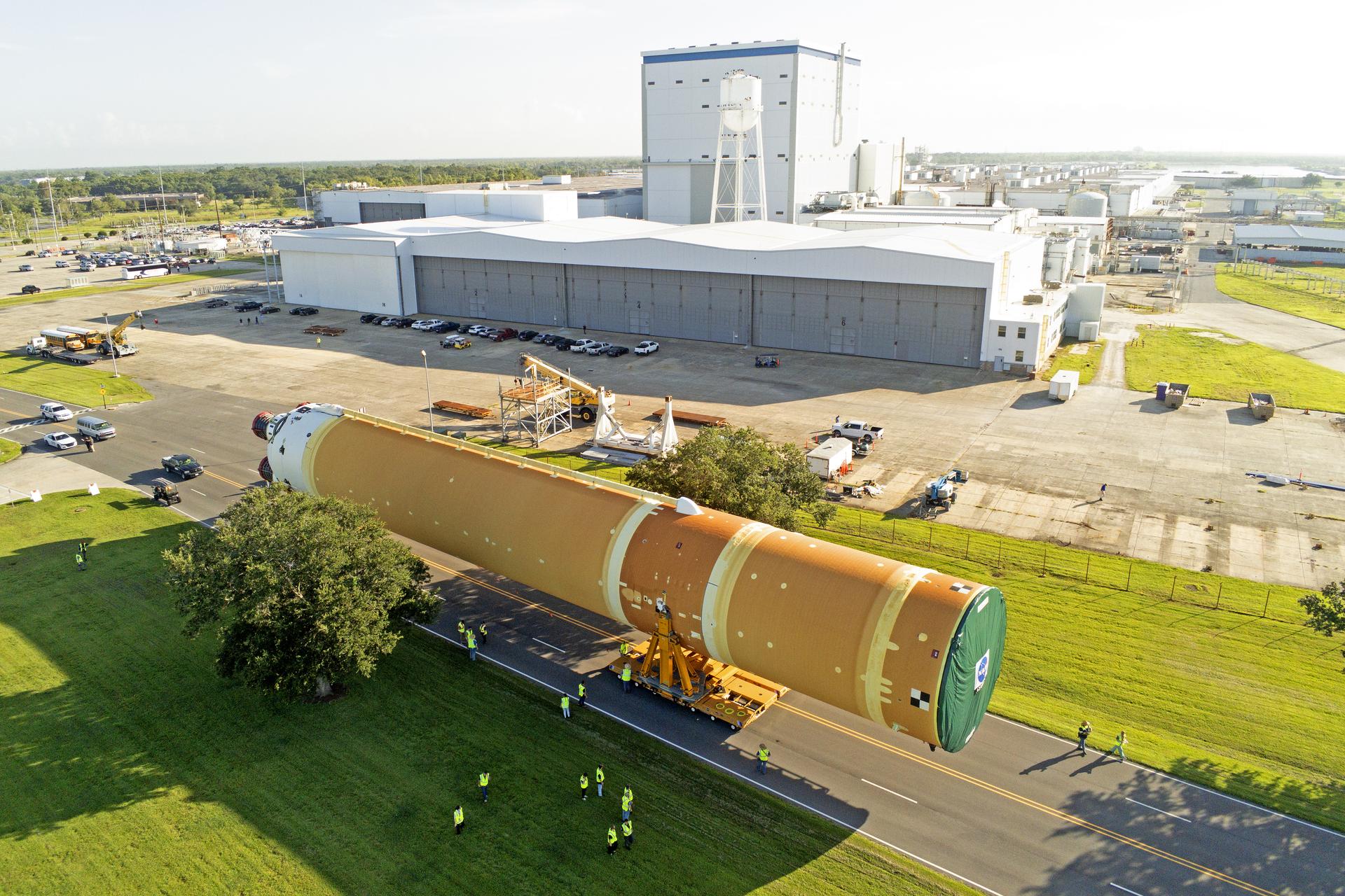 These images and videos show team members moving the first core stage that will help launch the first crewed flight of NASA’s SLS (Space Launch System) rocket for the agency’s Artemis II mission. The move marked the first time a fully assembled Moon rocket stage for a crewed mission has rolled out from NASA’s Michoud Assembly Facility in New Orleans since the Apollo Program, The core stage was moved onto the agency’s Pegasus barge, where it will be ferried to NASA’s Kennedy Space Center in Florida. The core stage for the SLS mega rocket is the largest stage NASA has ever produced. At 212 feet tall, the stage consists of five major elements, including two huge propellant tanks that collectively hold more than 733,000 gallons of super chilled liquid propellant to feed four RS-25 engines at its base. During launch and flight, the stage will operate for just over eight minutes, producing more than 2 million pounds of thrust to help send a crew of four astronauts inside NASA’s Orion spacecraft onward to the Moon. NASA is working to land the first woman, first person of color, and its first international partner astronaut on the Moon under Artemis. SLS is part of NASA’s backbone for deep space exploration, along with the Orion spacecraft and Gateway in orbit around the Moon and commercial human landing systems, next-generation space, next-generational spacesuits, and rovers on the lunar surface. SLS is the only rocket that can send Orion, astronauts, and supplies to the Moon in a single launch.