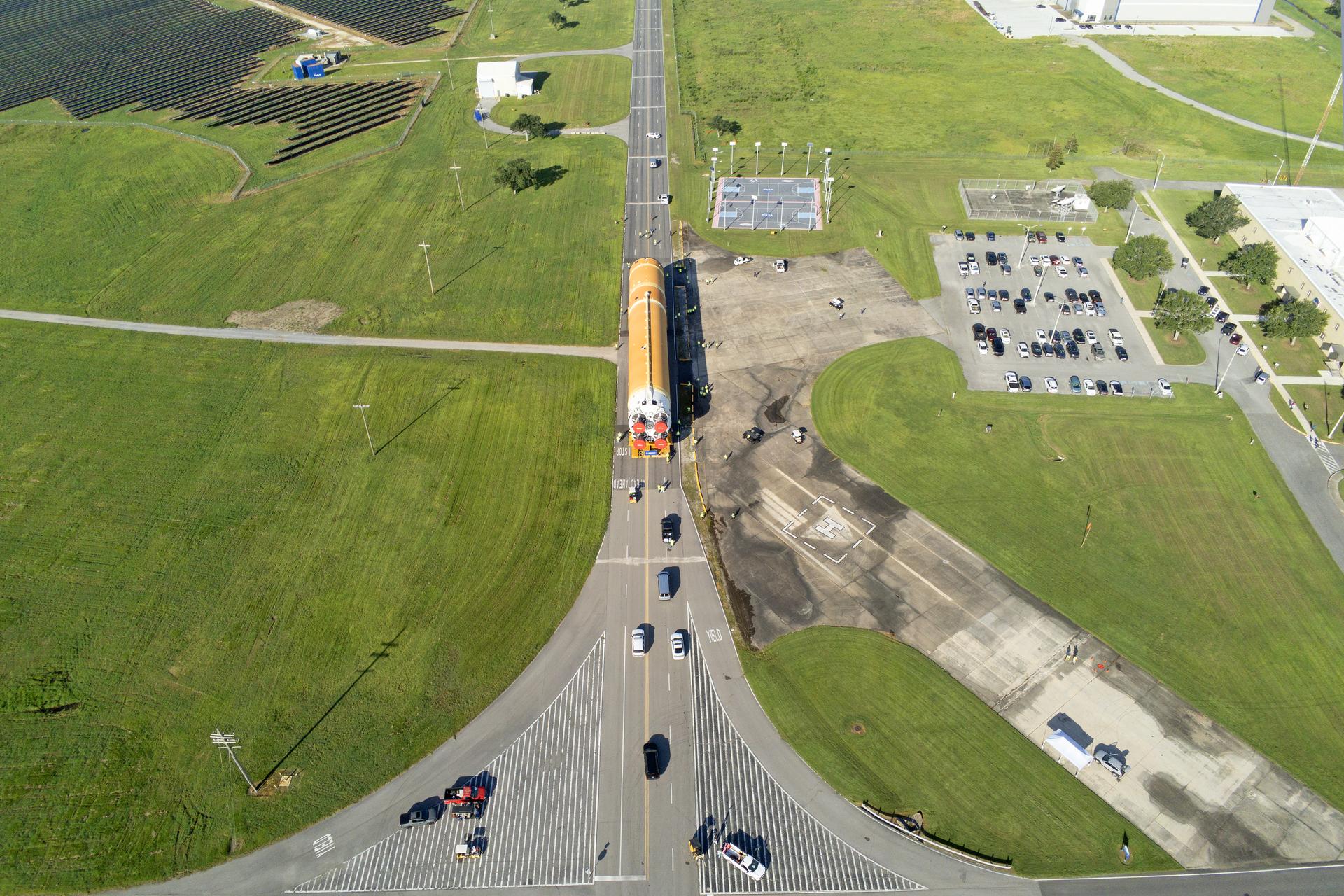 These images and videos show team members moving the first core stage that will help launch the first crewed flight of NASA’s SLS (Space Launch System) rocket for the agency’s Artemis II mission. The move marked the first time a fully assembled Moon rocket stage for a crewed mission has rolled out from NASA’s Michoud Assembly Facility in New Orleans since the Apollo Program, The core stage was moved onto the agency’s Pegasus barge, where it will be ferried to NASA’s Kennedy Space Center in Florida. The core stage for the SLS mega rocket is the largest stage NASA has ever produced. At 212 feet tall, the stage consists of five major elements, including two huge propellant tanks that collectively hold more than 733,000 gallons of super chilled liquid propellant to feed four RS-25 engines at its base. During launch and flight, the stage will operate for just over eight minutes, producing more than 2 million pounds of thrust to help send a crew of four astronauts inside NASA’s Orion spacecraft onward to the Moon. NASA is working to land the first woman, first person of color, and its first international partner astronaut on the Moon under Artemis. SLS is part of NASA’s backbone for deep space exploration, along with the Orion spacecraft and Gateway in orbit around the Moon and commercial human landing systems, next-generation space, next-generational spacesuits, and rovers on the lunar surface. SLS is the only rocket that can send Orion, astronauts, and supplies to the Moon in a single launch.