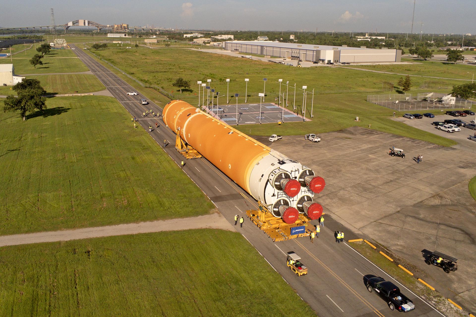 These images and videos show team members moving the first core stage that will help launch the first crewed flight of NASA’s SLS (Space Launch System) rocket for the agency’s Artemis II mission. The move marked the first time a fully assembled Moon rocket stage for a crewed mission has rolled out from NASA’s Michoud Assembly Facility in New Orleans since the Apollo Program, The core stage was moved onto the agency’s Pegasus barge, where it will be ferried to NASA’s Kennedy Space Center in Florida. The core stage for the SLS mega rocket is the largest stage NASA has ever produced. At 212 feet tall, the stage consists of five major elements, including two huge propellant tanks that collectively hold more than 733,000 gallons of super chilled liquid propellant to feed four RS-25 engines at its base. During launch and flight, the stage will operate for just over eight minutes, producing more than 2 million pounds of thrust to help send a crew of four astronauts inside NASA’s Orion spacecraft onward to the Moon. NASA is working to land the first woman, first person of color, and its first international partner astronaut on the Moon under Artemis. SLS is part of NASA’s backbone for deep space exploration, along with the Orion spacecraft and Gateway in orbit around the Moon and commercial human landing systems, next-generation space, next-generational spacesuits, and rovers on the lunar surface. SLS is the only rocket that can send Orion, astronauts, and supplies to the Moon in a single launch.