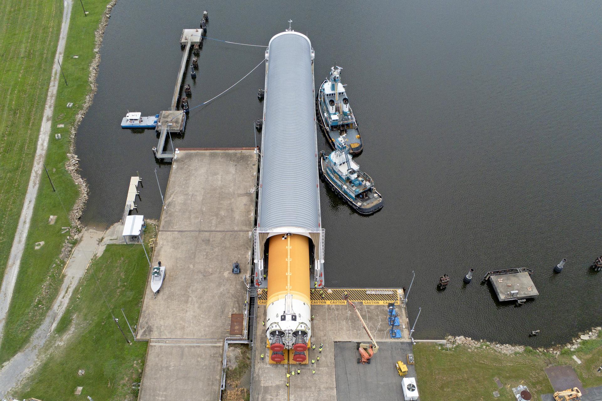 These images and videos show team members at Michoud Assembly Facility loading the first core stage that will help launch the first crewed flight of NASA’s SLS (Space Launch System) rocket for the agency’s Artemis II mission onto the Pegasus barge on Tuesday, July 16, 2024. The barge will ferry the core stage on a 900-mile journey from the agency’s Michoud Assembly Facility in New Orleans to its Kennedy Space Center in Florida. The core stage for the SLS mega rocket is the largest stage NASA has ever produced. At 212 feet tall, the stage consists of five major elements, including two huge propellant tanks that collectively hold more than 733,000 gallons of super chilled liquid propellant to feed four RS-25 engines at its base. During launch and flight, the stage will operate for just over eight minutes, producing more than 2 million pounds of thrust to help send a crew of four astronauts inside NASA’s Orion spacecraft onward to the Moon. All the major structures for every SLS core stage are fully manufactured at NASA Michoud. NASA is working to land the first woman, first person of color, and its first international partner astronaut on the Moon under Artemis. SLS is part of NASA’s backbone for deep space exploration, along with the Orion spacecraft and Gateway in orbit around the Moon and commercial human landing systems, next-generation space, next-generational spacesuits, and rovers on the lunar surface. SLS is the only rocket that can send Orion, astronauts, and supplies to the Moon in a single launch.
