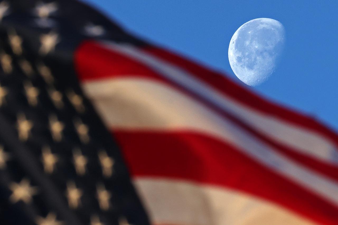 The waning gibbous Moon sets behind a flag at NASA’s Michoud Assembly Facility in New Orleans just after sunrise on Wednesday, March 19, 2025. Image credit: NASA/Michael DeMocker