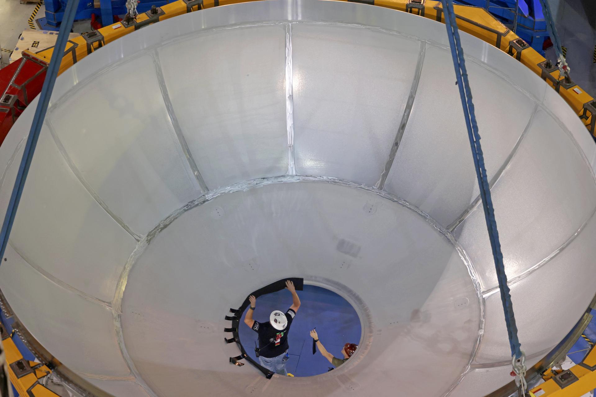 Move crews at NASA’s Michoud Assembly Facility in New Orleans lift the aft dome for the liquid hydrogen tank for the fourth core stage of NASA’s SLS (Space Launch System), into the in-feeder of the facility’s vertical assembly center. Once loaded into the production tool, teams with SLS prime contractor, Boeing, will circumferentially friction-stir weld the dome to the previously-welded forward dome and five barrels that make up the liquid hydrogen tank.    The SLS core stage liquid hydrogen tank holds 537,000 gallons of super-cooled propellant and is one of five unique elements that make up the SLS core stage. Together with the forward skirt, liquid oxygen tank, intertank, and engine section, the liquid hydrogen tank will provide propellant to the four RS-25 engines to produce more than two million pounds of thrust to help launch NASA’s Orion spacecraft, astronauts, and supplies beyond Earth’s orbit to the Moon.    Image credit: NASA/Michael DeMocker