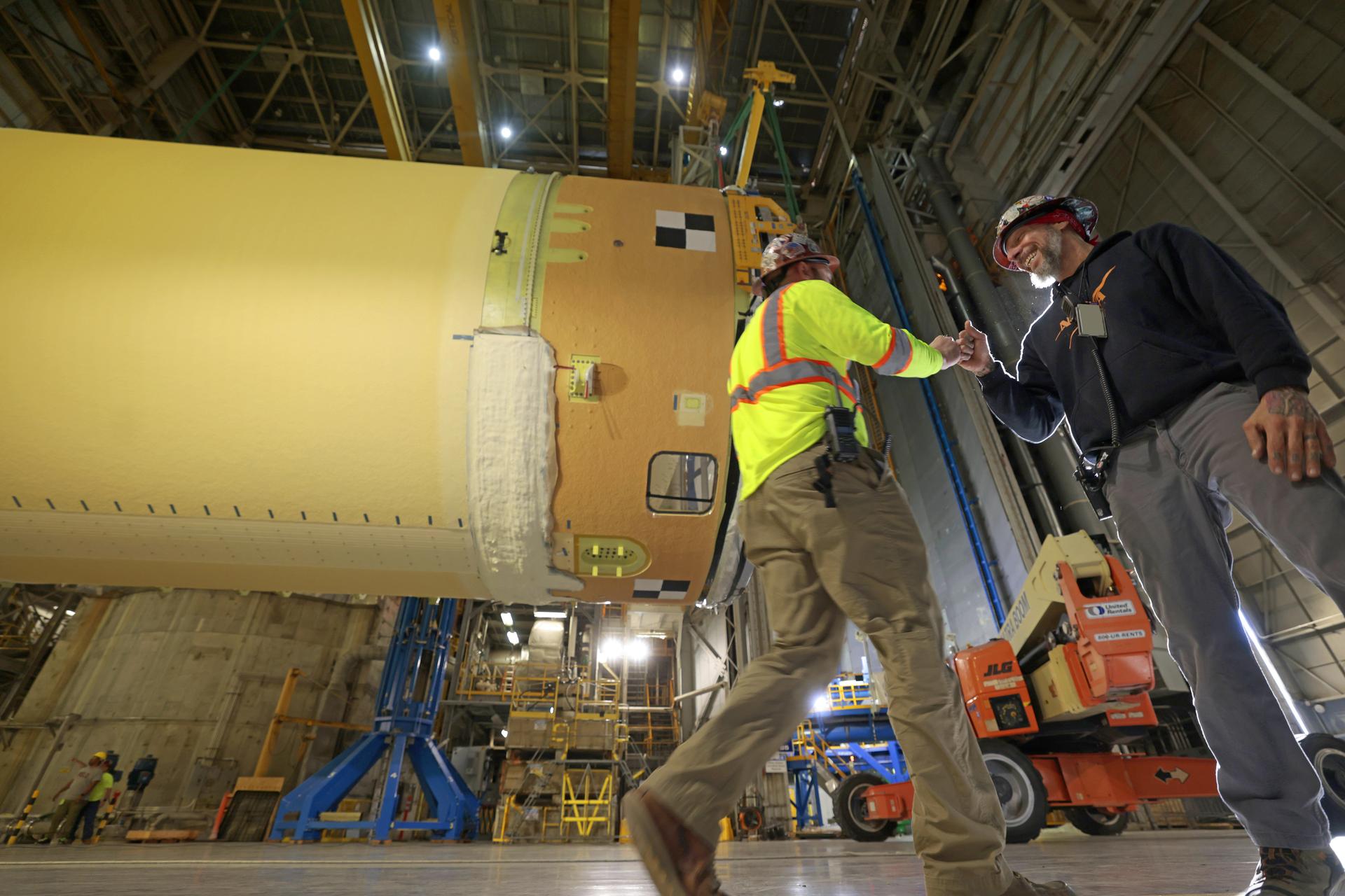 Move crews at NASA’s Michoud Assembly Facility in New Orleans, lift the forward-joined flight hardware for the agency’s SLS (Space Launch System) rocket out of a stacking cell in the vertical assembly building on Dec. 19, 2025. The forward join, which consists of the intertank, liquid oxygen tank, and forward skirt, will be used on the core stage slated for NASA’s Artemis III mission. Teams moved the flight hardware from the cell and set it atop self-propelled mobile transporters. Soon, the article will be brought to the factory’s final assembly area where it will be mated to the core stage’s previously joined liquid hydrogen tank and undergo further integration. The core stage, along with its four RS-25 engines, produce more than two million pounds of thrust to help launch NASA’s Orion spacecraft, astronauts, and supplies beyond Earth’s orbit and to the lunar surface for Artemis. Image credit: NASA/Michael DeMocker
