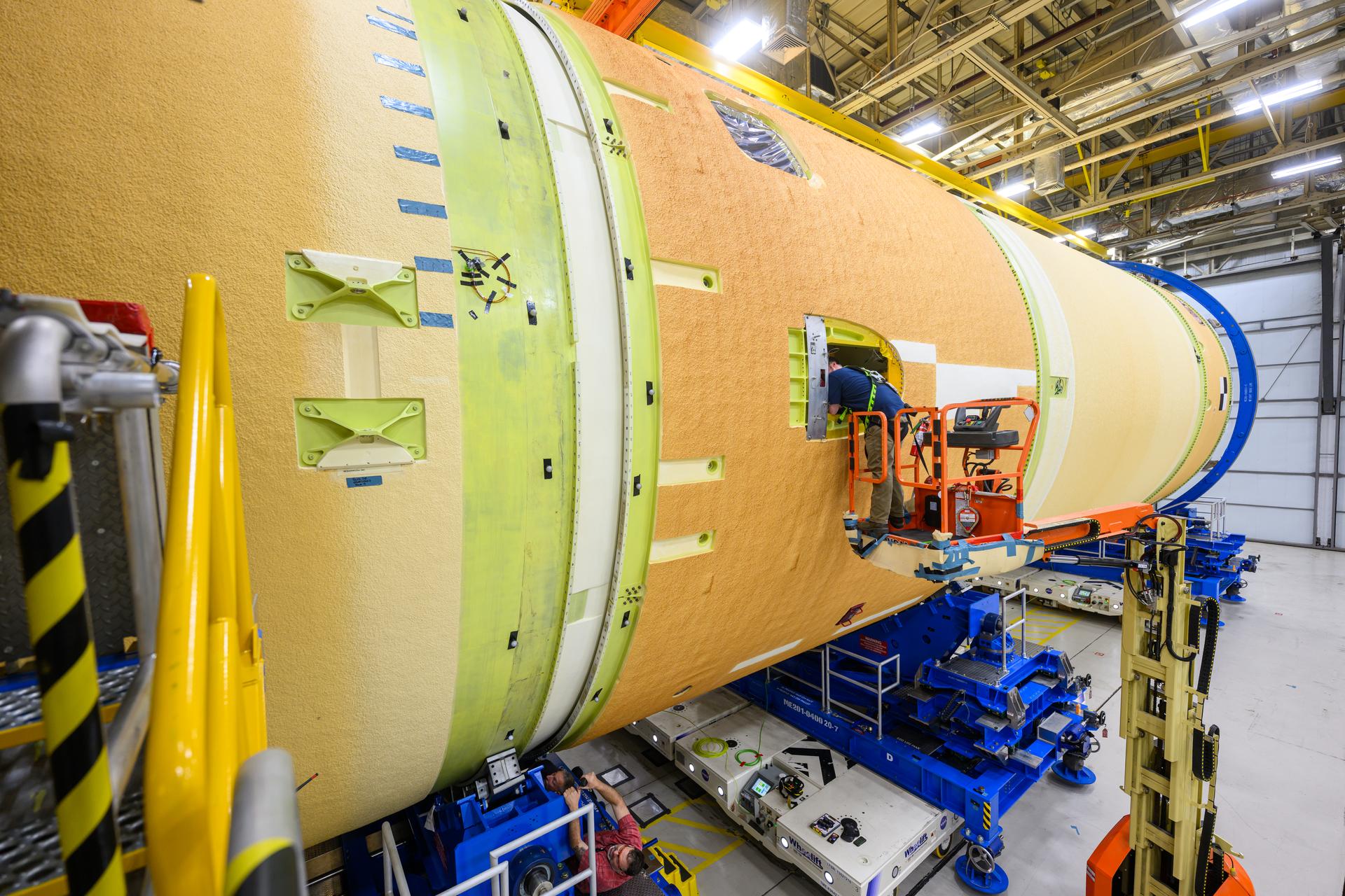 These images and videos show technicians horizontally joining the forward and aft ends of the SLS (Space Launch System) core stage. All pieces of flight hardware are covered in the off-white-turning-tan thermal protection system and are 27.6 feet in diameter.