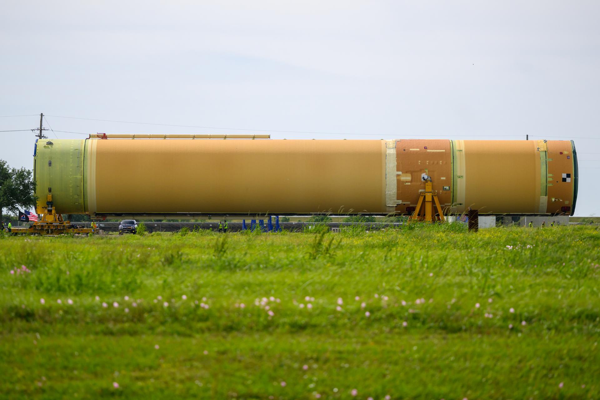 NASA moved the core stage, or the largest section, of the SLS (Space Launch System) rocket that will launch the crewed Artemis III mission in 2027 from the agency’s Michoud Assembly Facility to the agency’s Pegasus barge in New Orleans on April 20. The barge will ferry the top four-fifths – the section containing the liquid hydrogen tank, liquid oxygen tank, intertank, and forward skirt – of the SLS core stage to NASA’s Kennedy Space Center in Florida to complete outfitting and vertical integration.  Teams with NASA and Boeing, the SLS core stage lead contractor, used specialized transporters to guide the top four-fifths from the NASA rocket factory to Pegasus. Prior to the move, technicians added an engine section transportation simulator to the rocket stage for shipment to the Space Coast.  Next year’s Artemis III mission will launch astronauts to Earth’s orbit aboard the Orion spacecraft on top of SLS to test rendezvous and docking capabilities between Orion and commercial spacecraft needed to land Artemis IV astronauts on the Moon in 2028. NASA’s SLS is the only rocket capable of sending Orion, astronauts, and supplies to the Moon in a single launch.  