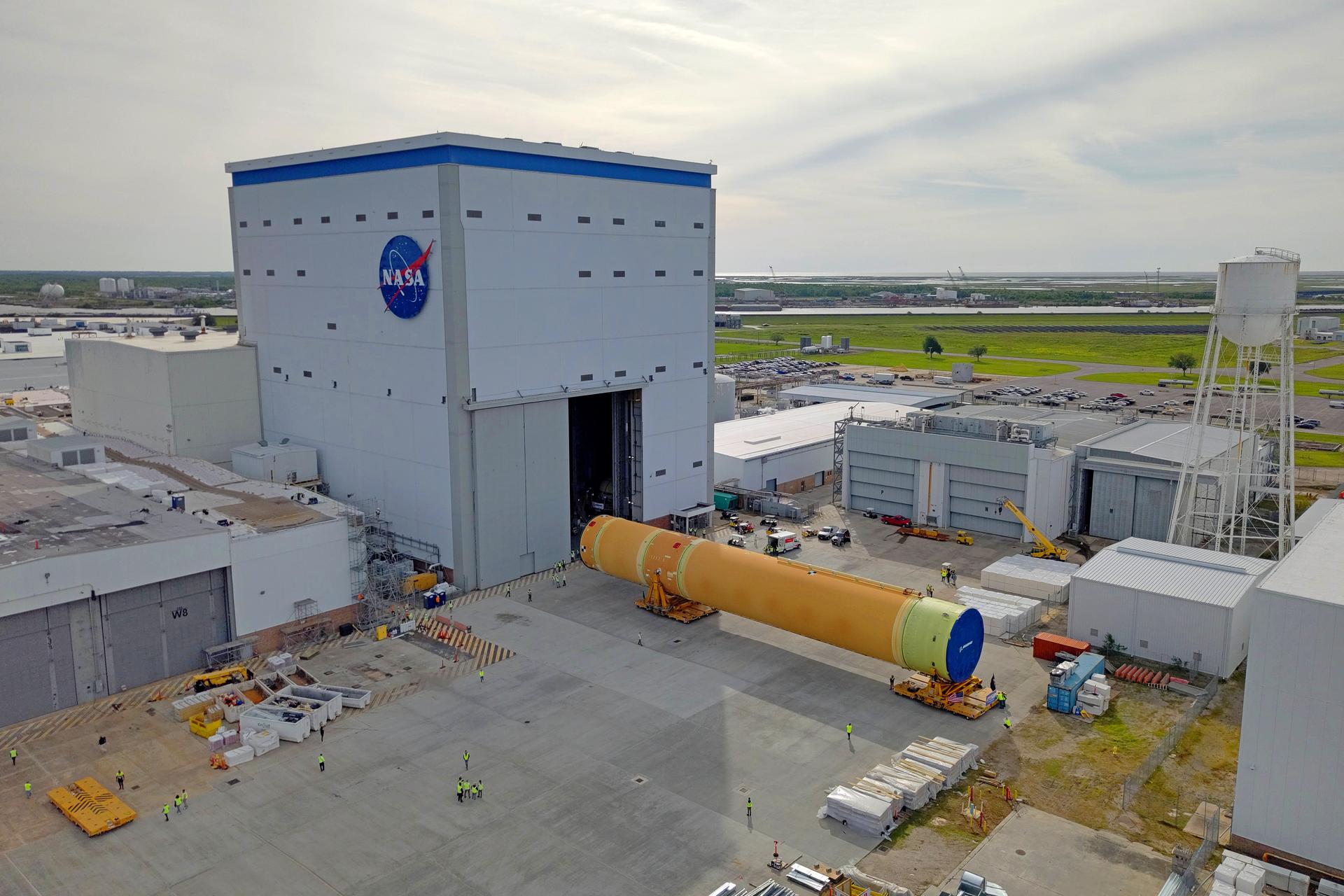 NASA moved the core stage, or the largest section, of the SLS (Space Launch System) rocket that will launch the crewed Artemis III mission in 2027 from the agency’s Michoud Assembly Facility to the agency’s Pegasus barge in New Orleans on April 20. The barge will ferry the top four-fifths – the section containing the liquid hydrogen tank, liquid oxygen tank, intertank, and forward skirt – of the SLS core stage to NASA’s Kennedy Space Center in Florida to complete outfitting and vertical integration.  Teams with NASA and Boeing, the SLS core stage lead contractor, used specialized transporters to guide the top four-fifths from the NASA rocket factory to Pegasus. Prior to the move, technicians added an engine section transportation simulator to the rocket stage for shipment to the Space Coast.  Next year’s Artemis III mission will launch astronauts to Earth’s orbit aboard the Orion spacecraft on top of SLS to test rendezvous and docking capabilities between Orion and commercial spacecraft needed to land Artemis IV astronauts on the Moon in 2028. NASA’s SLS is the only rocket capable of sending Orion, astronauts, and supplies to the Moon in a single launch.  Image credit: NASA/Michael DeMocker