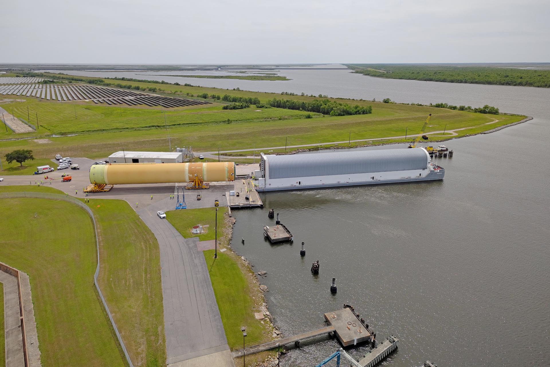 NASA moved the core stage, or the largest section, of the SLS (Space Launch System) rocket that will launch the crewed Artemis III mission in 2027 from the agency’s Michoud Assembly Facility to the agency’s Pegasus barge in New Orleans on April 20. The barge will ferry the top four-fifths – the section containing the liquid hydrogen tank, liquid oxygen tank, intertank, and forward skirt – of the SLS core stage to NASA’s Kennedy Space Center in Florida to complete outfitting and vertical integration.  Teams with NASA and Boeing, the SLS core stage lead contractor, used specialized transporters to guide the top four-fifths from the NASA rocket factory to Pegasus. Prior to the move, technicians added an engine section transportation simulator to the rocket stage for shipment to the Space Coast.  Next year’s Artemis III mission will launch astronauts to Earth’s orbit aboard the Orion spacecraft on top of SLS to test rendezvous and docking capabilities between Orion and commercial spacecraft needed to land Artemis IV astronauts on the Moon in 2028. NASA’s SLS is the only rocket capable of sending Orion, astronauts, and supplies to the Moon in a single launch. 