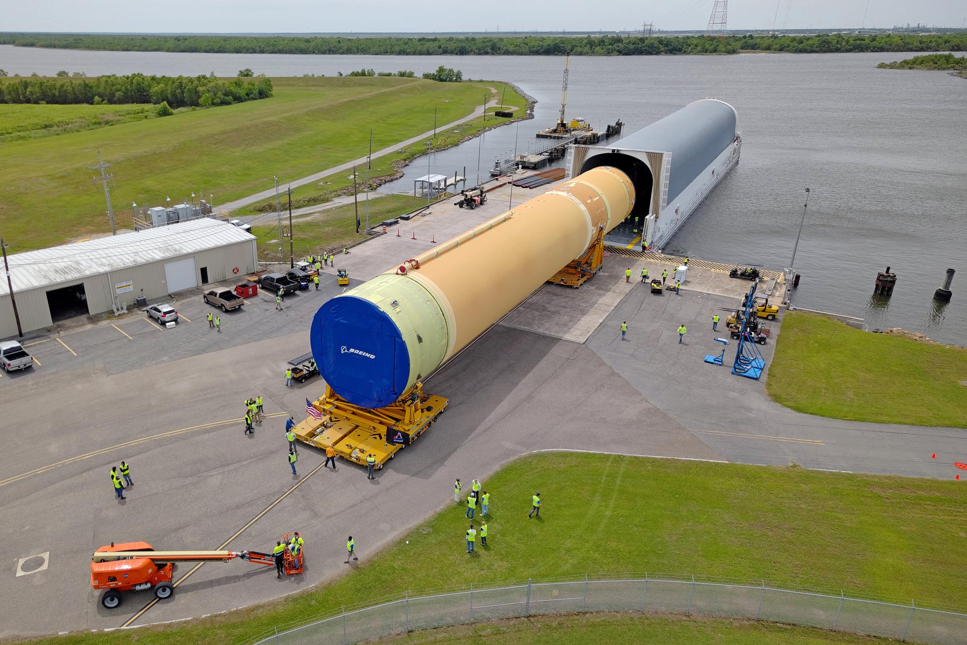 NASA moved the core stage, or the largest section, of the SLS (Space Launch System) rocket that will launch the crewed Artemis III mission in 2027 from the agency’s Michoud Assembly Facility to the agency’s Pegasus barge in New Orleans on April 20. The barge will ferry the top four-fifths – the section containing the liquid hydrogen tank, liquid oxygen tank, intertank, and forward skirt – of the SLS core stage to NASA’s Kennedy Space Center in Florida to complete outfitting and vertical integration.  Teams with NASA and Boeing, the SLS core stage lead contractor, used specialized transporters to guide the top four-fifths from the NASA rocket factory to Pegasus. Prior to the move, technicians added an engine section transportation simulator to the rocket stage for shipment to the Space Coast.  Next year’s Artemis III mission will launch astronauts to Earth’s orbit aboard the Orion spacecraft on top of SLS to test rendezvous and docking capabilities between Orion and commercial spacecraft needed to land Artemis IV astronauts on the Moon in 2028. NASA’s SLS is the only rocket capable of sending Orion, astronauts, and supplies to the Moon in a single launch.  Image credit: NASA/Michael DeMocker