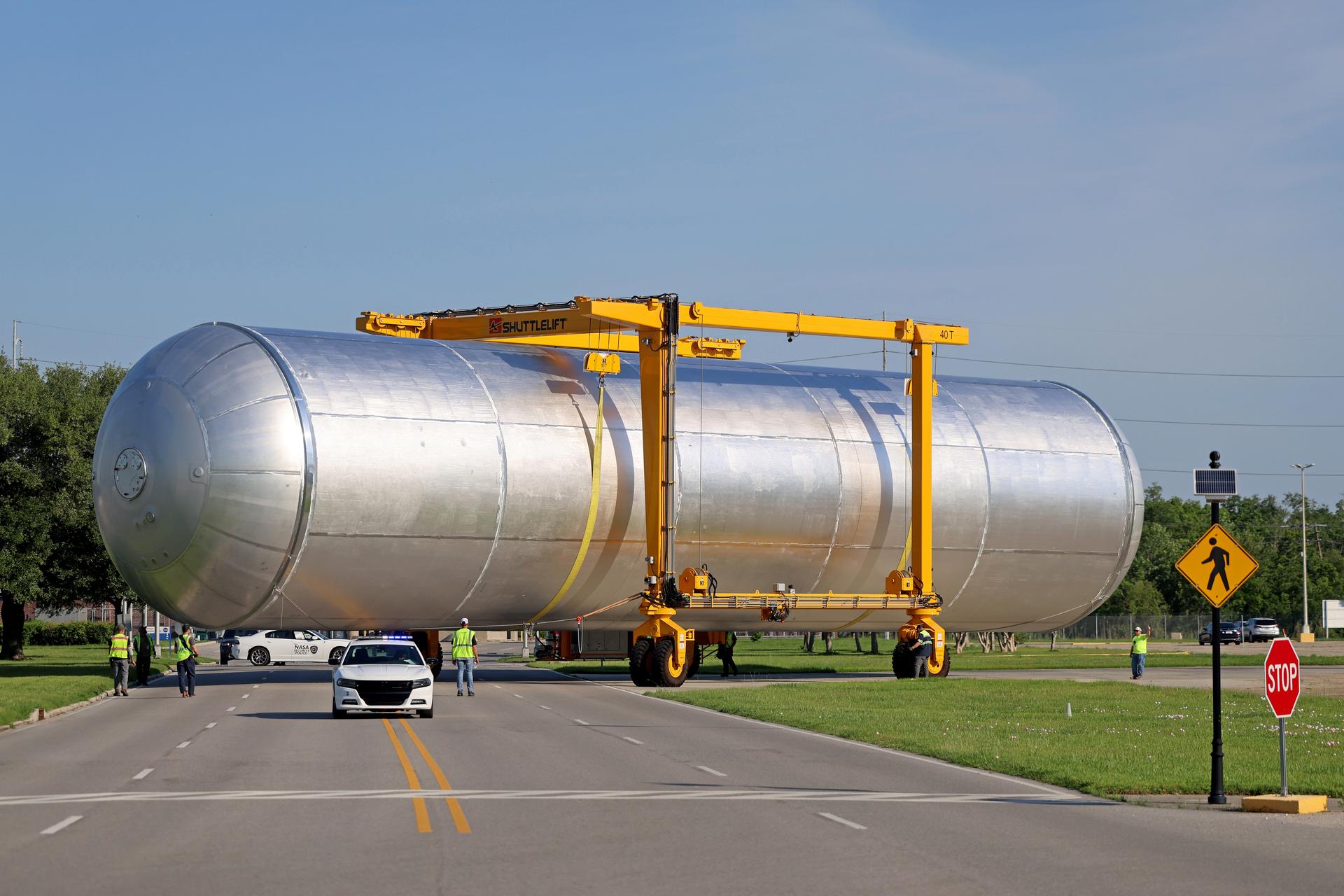 Crews at NASA’s Michoud Assembly Facility in New Orleans transport the 130-foot-tall liquid hydrogen tank out of a production cell inside the main factory building into a detached test building on a separate portion of the 829-acre site. The liquid hydrogen tank will form part of the core stage for the SLS (Space Launch System) rocket, providing thousands of gallons of super-cold propellant to one of four RS-25 engines. Inside the test cell, teams will perform non-destructive evaluation proof testing on the tank. Proof testing ensures the structural integrity of the flight hardware before crews begin the next phase of production. The liquid hydrogen propellant tank is one of five major elements that make up the 212-foot-tall SLS rocket stage. The core stage, along with its four RS-25 engines at its base, produce more than two million pounds of thrust to help launch NASA’s Orion spacecraft, astronauts, and supplies beyond Earth’s orbit and to the lunar surface for Artemis. Image credit: NASA/Michael DeMocker