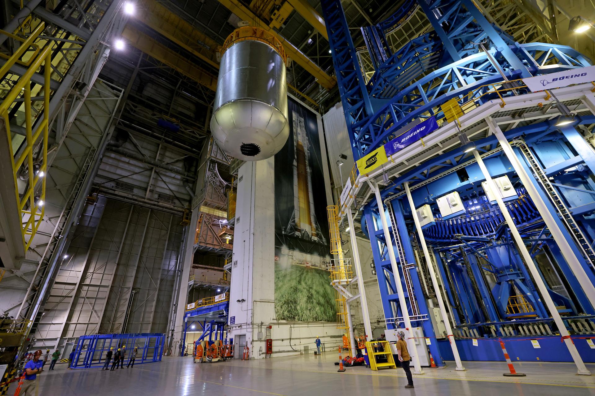 Teams at NASA’s Michoud Assembly Facility in New Orleans use an overhead crane to lift a 51-foot-tall liquid oxygen tank out of the vertical assembly center on May 26. The liquid oxygen tank will form part of the SLS (Space Launch System) rocket for NASA’s Artemis IV mission to the Moon. It will hold more than 196,000 gallons of super-cold liquid oxygen; and next, technicians with Boeing, SLS core stage prime contractor, and NASA will perform dimensional inspections and install internal baffles on the propellant tank before the next phase of production.    The propellant tank is one of five major elements that make up the 212-foot-tall SLS rocket stage. The core stage, along with its four RS-25 engines at its base, produces more than two million pounds of thrust to help launch NASA’s Orion spacecraft, astronauts, and supplies beyond Earth’s orbit and to the lunar surface for Artemis.      Image credit: NASA/Michael DeMocker