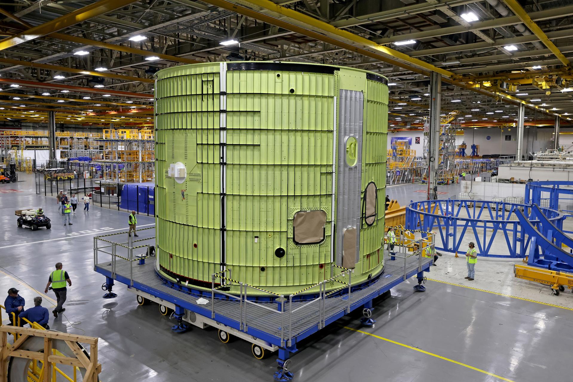 Teams at NASA’s Michoud Assembly Facility in New Orleans move the 21.8-foot-tall intertank for the core stage of the agency’s SLS (Space Launch System) rocket into one of the factory’s high bay production cells May 29. The flight hardware will help power NASA’s Artemis IV mission. Inside the production cell, NASA and Boeing, SLS core stage prime contractor will apply the hardware’s outer thermal protection layer through an automated process. The thermal protection system safeguards the rocket from the extreme temperatures and prevents the super-cooled propellant within the rocket’s massive propellant tanks from boiling off too rapidly during launch and flight.    The intertank houses avionics and electronics, serves as an attachment point for the solid rocket boosters, and is one of five major elements that make up the 212-foot-tall rocket stage. The core stage, along with its four RS-25 engines at its base, produce more than two million pounds of thrust to help launch NASA’s Orion spacecraft, astronauts, and supplies beyond Earth’s orbit and to the lunar surface for Artemis.      Image credit: NASA/Michael DeMocker