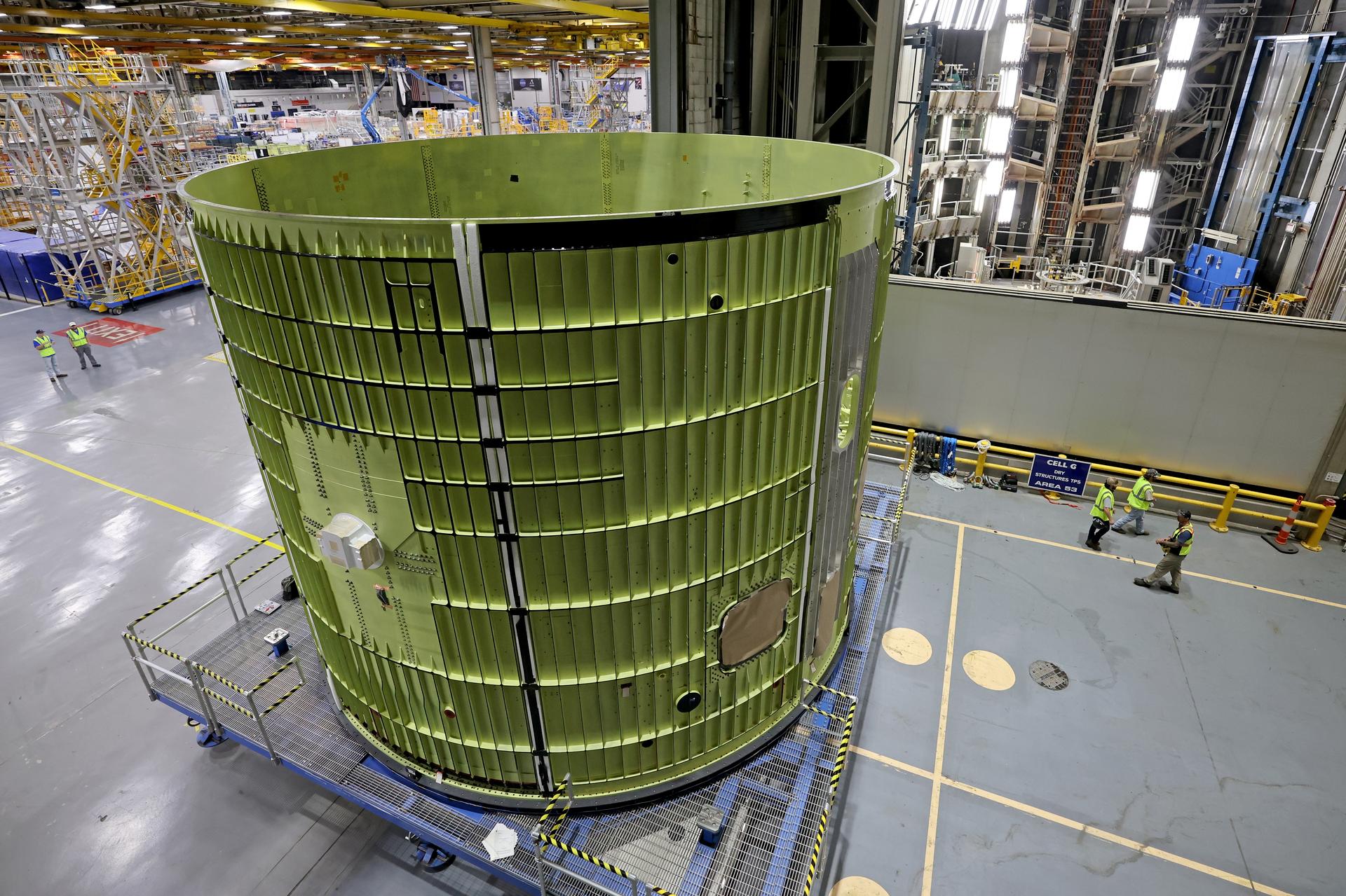 Teams at NASA’s Michoud Assembly Facility in New Orleans move the 21.8-foot-tall intertank for the core stage of the agency’s SLS (Space Launch System) rocket into one of the factory’s high bay production cells May 29. The flight hardware will help power NASA’s Artemis IV mission. Inside the production cell, NASA and Boeing, SLS core stage prime contractor will apply the hardware’s outer thermal protection layer through an automated process. The thermal protection system safeguards the rocket from the extreme temperatures and prevents the super-cooled propellant within the rocket’s massive propellant tanks from boiling off too rapidly during launch and flight.    The intertank houses avionics and electronics, serves as an attachment point for the solid rocket boosters, and is one of five major elements that make up the 212-foot-tall rocket stage. The core stage, along with its four RS-25 engines at its base, produce more than two million pounds of thrust to help launch NASA’s Orion spacecraft, astronauts, and supplies beyond Earth’s orbit and to the lunar surface for Artemis.      Image credit: NASA/Michael DeMocker