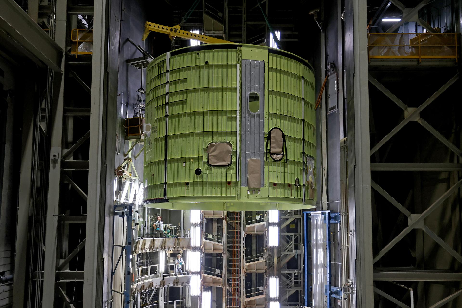 Teams at NASA’s Michoud Assembly Facility in New Orleans move the 21.8-foot-tall intertank for the core stage of the agency’s SLS (Space Launch System) rocket into one of the factory’s high bay production cells May 29. The flight hardware will help power NASA’s Artemis IV mission. Inside the production cell, NASA and Boeing, SLS core stage prime contractor will apply the hardware’s outer thermal protection layer through an automated process. The thermal protection system safeguards the rocket from the extreme temperatures and prevents the super-cooled propellant within the rocket’s massive propellant tanks from boiling off too rapidly during launch and flight.    The intertank houses avionics and electronics, serves as an attachment point for the solid rocket boosters, and is one of five major elements that make up the 212-foot-tall rocket stage. The core stage, along with its four RS-25 engines at its base, produce more than two million pounds of thrust to help launch NASA’s Orion spacecraft, astronauts, and supplies beyond Earth’s orbit and to the lunar surface for Artemis.      Image credit: NASA/Michael DeMocker
