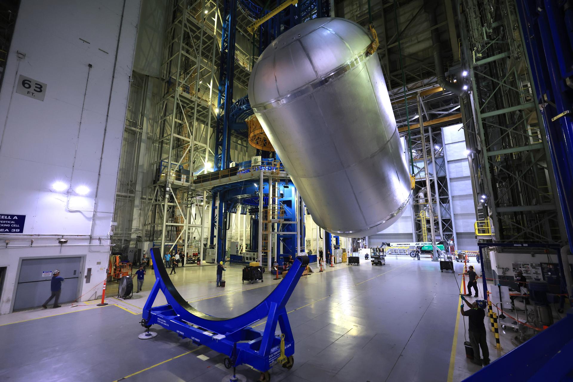 Teams at NASA’s Michoud Assembly Facility in New Orleans use an overhead crane to lift a 51-foot-tall liquid oxygen tank out of a production cell and into the main aisle of the vertical assembly building on June 9. The team rotates the tank from a vertical to a horizontal configuration in an operation called a “breakover,” and sets the tank into a pair of cradles until it is moved to its next phase of production. This liquid oxygen tank will form part of the SLS (Space Launch System) rocket for NASA’s Artemis IV mission to the Moon, and it will hold more than 196,000 gallons of super-cold liquid oxygen at launch. The propellant tank is one of five major elements that make up the 212-foot-tall SLS rocket stage. The core stage, along with its four RS-25 engines at its base, produces more than two million pounds of thrust to help launch NASA’s Orion spacecraft, astronauts, and supplies beyond Earth’s orbit and to the lunar surface for Artemis. Image credit: NASA/Michael DeMocker