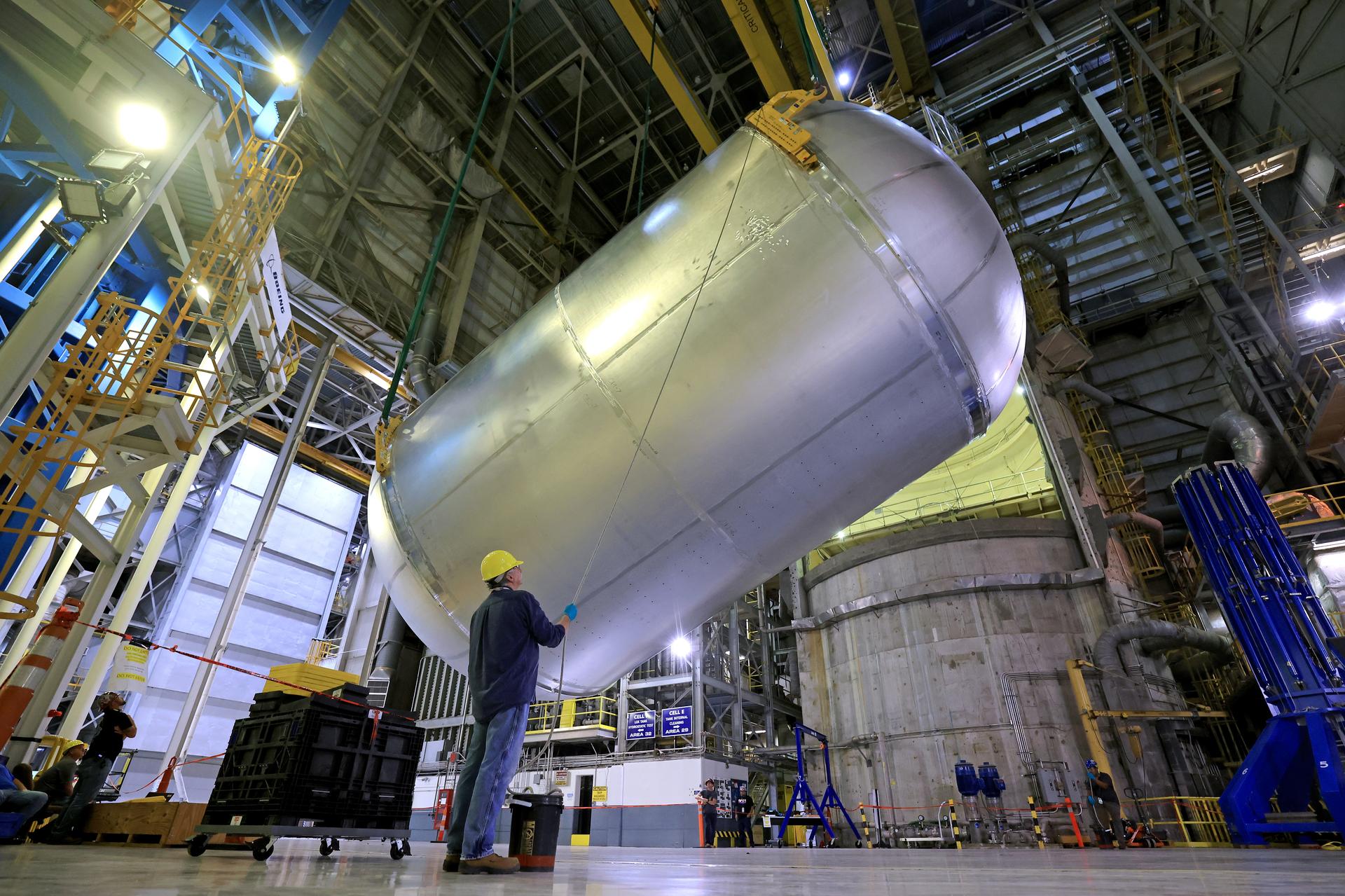 Teams at NASA’s Michoud Assembly Facility in New Orleans use an overhead crane to lift a 51-foot-tall liquid oxygen tank out of a production cell and into the main aisle of the vertical assembly building on June 9. The team rotates the tank from a vertical to a horizontal configuration in an operation called a “breakover,” and sets the tank into a pair of cradles until it is moved to its next phase of production. This liquid oxygen tank will form part of the SLS (Space Launch System) rocket for NASA’s Artemis IV mission to the Moon, and it will hold more than 196,000 gallons of super-cold liquid oxygen at launch. The propellant tank is one of five major elements that make up the 212-foot-tall SLS rocket stage. The core stage, along with its four RS-25 engines at its base, produces more than two million pounds of thrust to help launch NASA’s Orion spacecraft, astronauts, and supplies beyond Earth’s orbit and to the lunar surface for Artemis. Image credit: NASA/Michael DeMocker