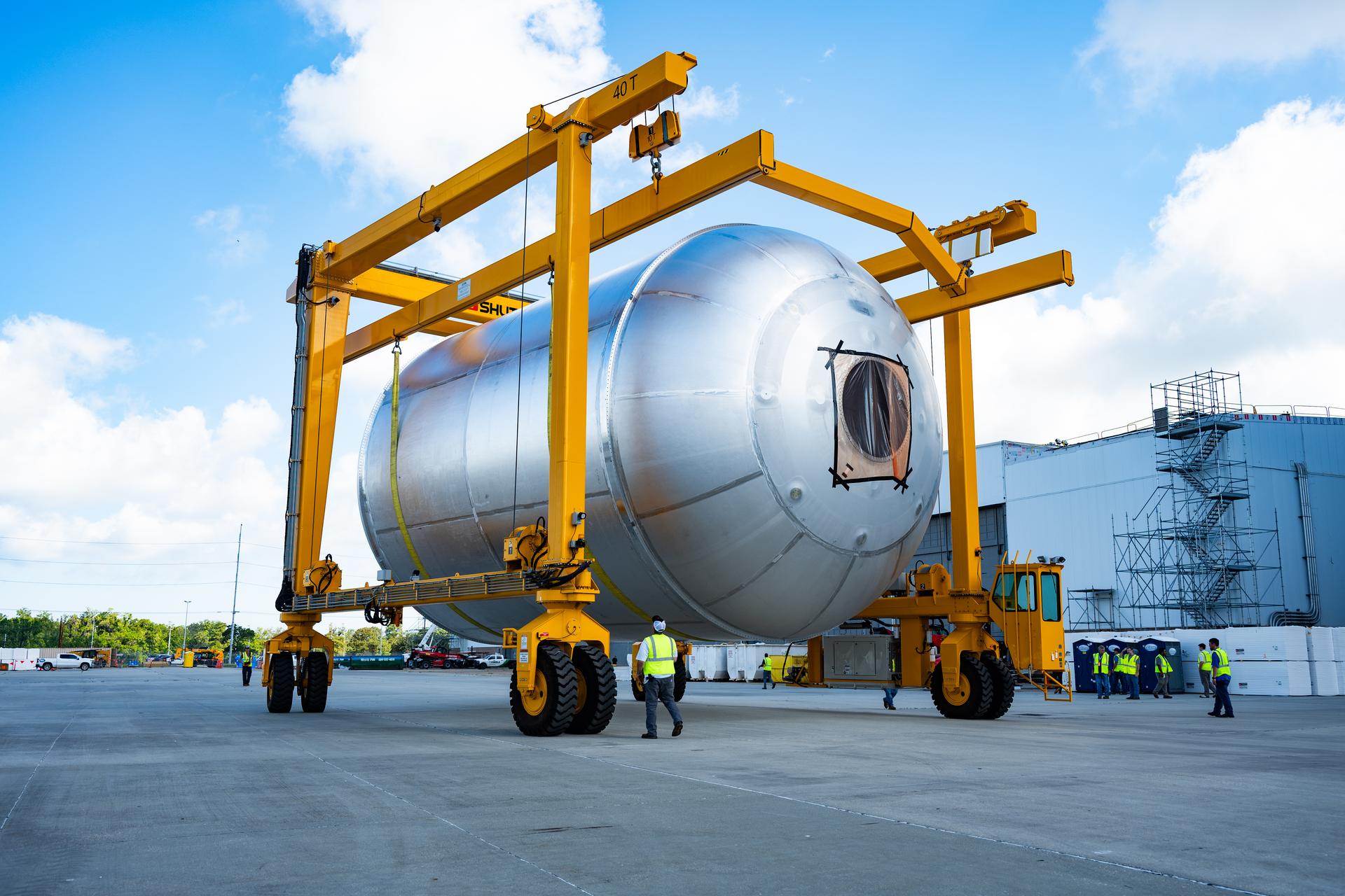 Teams at NASA’s Michoud Assembly Facility in New Orleans use a heavy-lift mobile transport apparatus to move a 51-foot-tall liquid oxygen tank out of the vertical assembly building and into the main rocket factory on June 11. The liquidoxygen tank will form part of the SLS (Space Launch System) rocket for NASA’s Artemis IV mission to the Moon. Next, technicians with Boeing, SLS core stage prime contractor, and NASA will perform dimensional inspections and install internal baffles on the propellant tank before the next phase of production. The propellant tank will hold more than 196,000 gallons of super-cooled liquid oxygen at launch and is one of five major elements that make up the 212-foot-tall SLS rocket stage. The core stage, along with its four RS-25 engines at its base, produces more than two million pounds of thrust to help launch NASA’s Orion spacecraft, ronauts, and supplies beyond Earth’s orbit and to the lunar surface for Artemis.