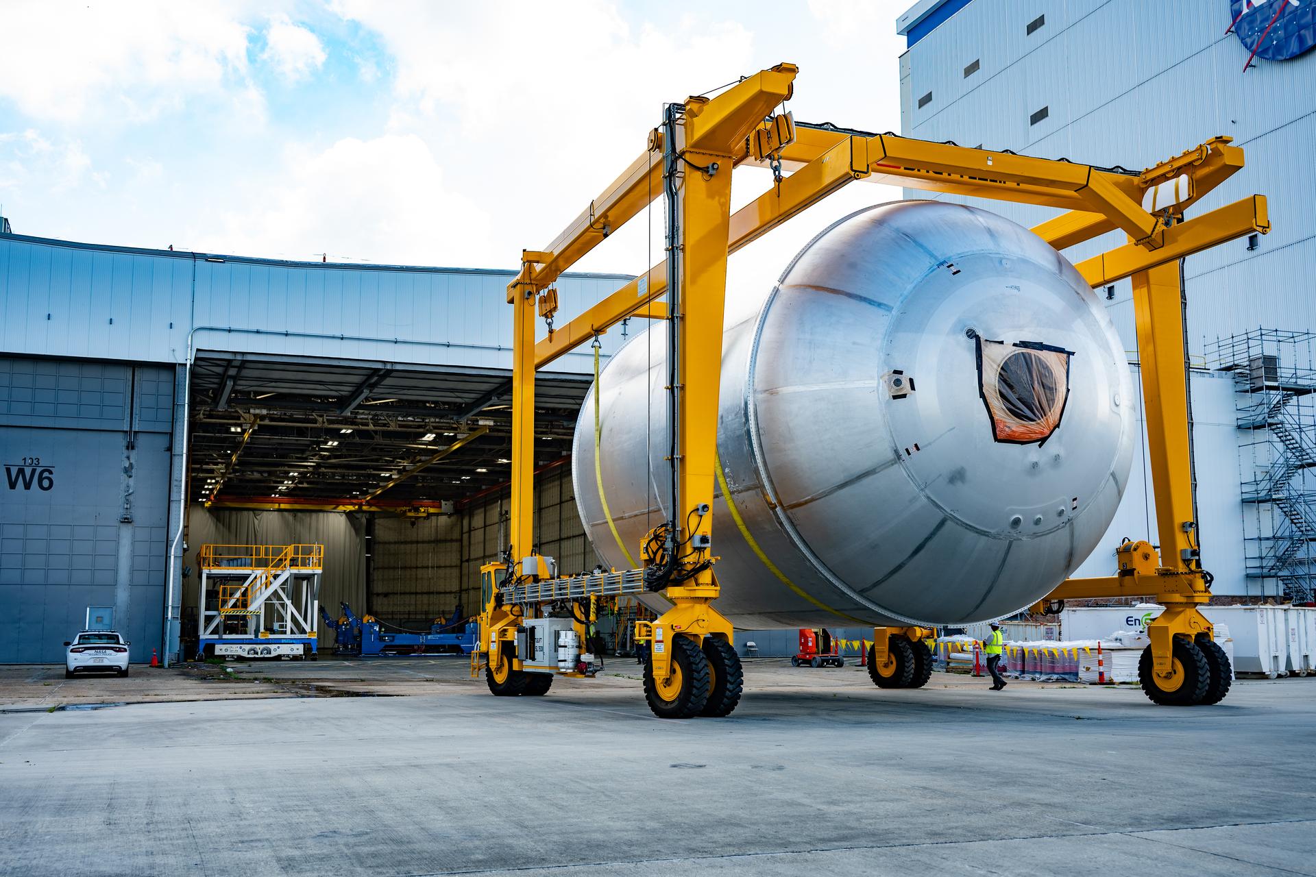 Teams at NASA’s Michoud Assembly Facility in New Orleans use a heavy-lift mobile transport apparatus to move a 51-foot-tall liquid oxygen tank out of the vertical assembly building and into the main rocket factory on June 11. The liquidoxygen tank will form part of the SLS (Space Launch System) rocket for NASA’s Artemis IV mission to the Moon. Next, technicians with Boeing, SLS core stage prime contractor, and NASA will perform dimensional inspections and install internal baffles on the propellant tank before the next phase of production. The propellant tank will hold more than 196,000 gallons of super-cooled liquid oxygen at launch and is one of five major elements that make up the 212-foot-tall SLS rocket stage. The core stage, along with its four RS-25 engines at its base, produces more than two million pounds of thrust to help launch NASA’s Orion spacecraft, ronauts, and supplies beyond Earth’s orbit and to the lunar surface for Artemis.