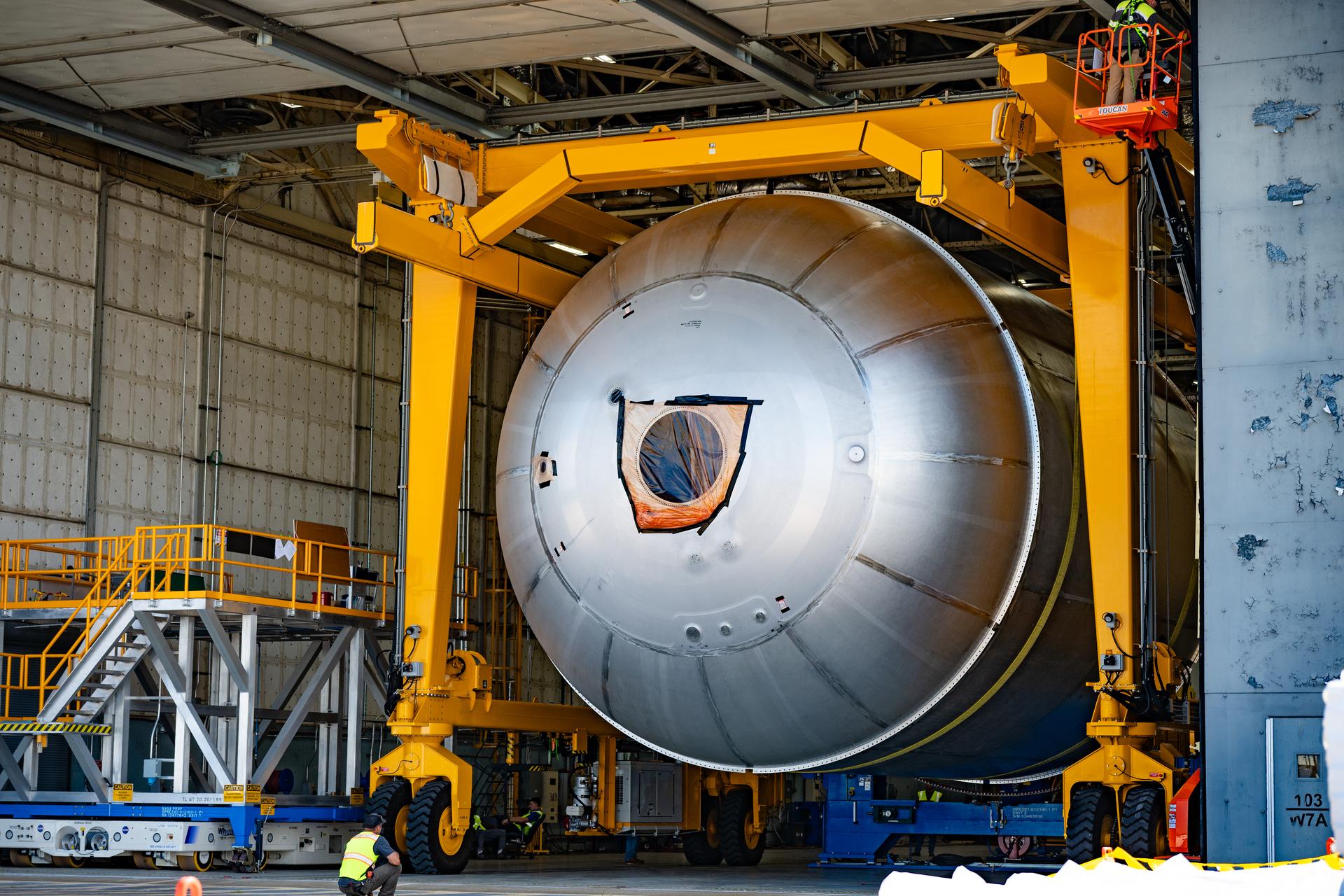 Teams at NASA’s Michoud Assembly Facility in New Orleans use a heavy-lift mobile transport apparatus to move a 51-foot-tall liquid oxygen tank out of the vertical assembly building and into the main rocket factory on June 11. The liquidoxygen tank will form part of the SLS (Space Launch System) rocket for NASA’s Artemis IV mission to the Moon. Next, technicians with Boeing, SLS core stage prime contractor, and NASA will perform dimensional inspections and install internal baffles on the propellant tank before the next phase of production. The propellant tank will hold more than 196,000 gallons of super-cooled liquid oxygen at launch and is one of five major elements that make up the 212-foot-tall SLS rocket stage. The core stage, along with its four RS-25 engines at its base, produces more than two million pounds of thrust to help launch NASA’s Orion spacecraft, ronauts, and supplies beyond Earth’s orbit and to the lunar surface for Artemis.